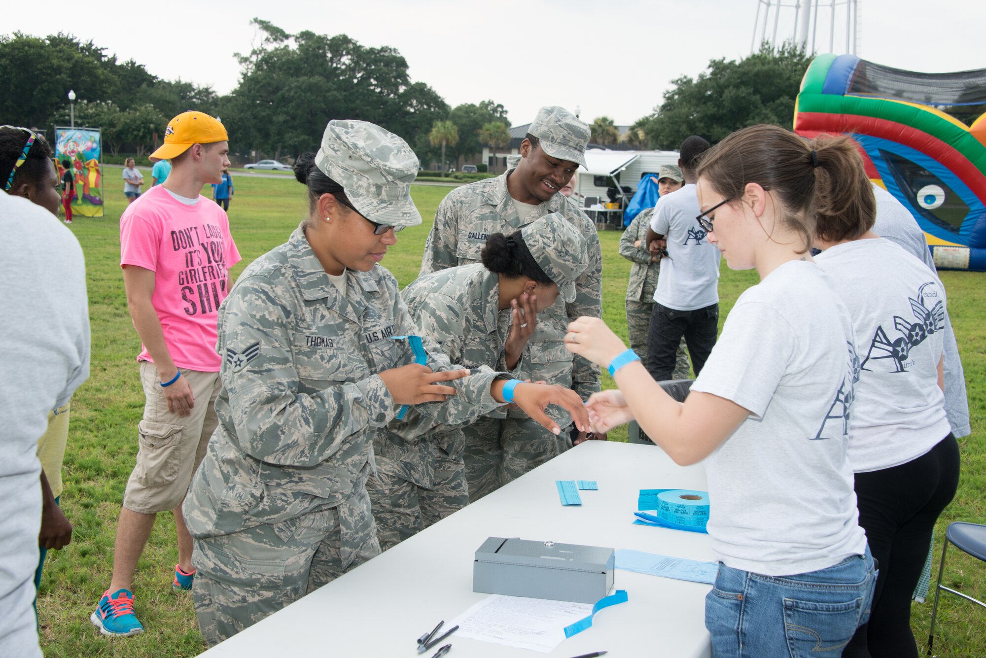 Airmen receive wrist bands for food and raffle tickets during a block party July 25, 2014, next to the Shaw House, Keesler Air Force Base, Miss.  The event, hosted by the Airman's Council and the Dorm Council, was open to all ranks and benefitted the 81st Training Wing Airmen recognition fund. (U.S. Air Force photo by Marie Floyd)