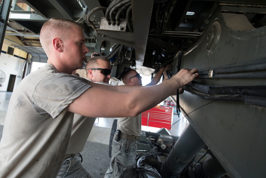 Airmen from the 23d Logistics Readiness Squadron vehicle maintenance flight repair the hydraulic system on an aircraft loader at Moody Air Force Base, Ga., July 28, 2014. The loader is capable of lifting up to 25 kilograms of cargo onto the HC-130J Combat King II. (U.S. Air Force photo by Airman 1st Class Dillian Bamman/Released)