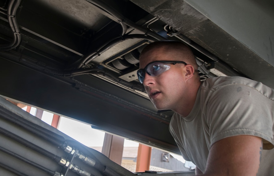 U.S. Air Force Staff Sgt. Michael Gustin, 23d Logistics Readiness Squadron vehicle maintenance journeyman, checks for leaks in an aircraft loader’s hydraulic system at Moody Air Force Base, Ga., July 28, 2014.  Many of the loader’s hydraulic pipes had to be replaced due to irreparable fluid leaks. (U.S. Air Force photo by Airman 1st Class Dillian Bamman/Released)