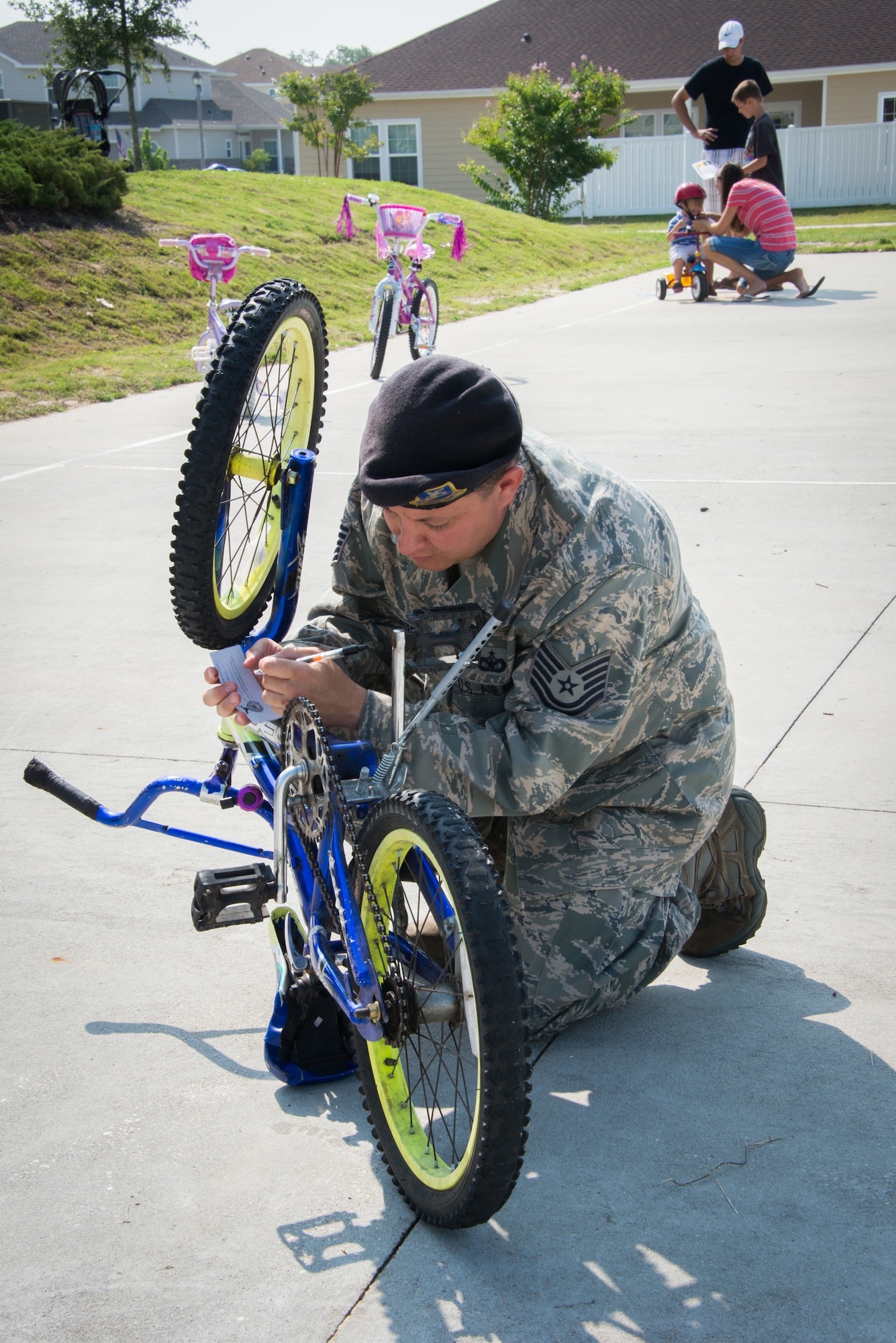 Tech. Sgt. Jason Palmitessa, 81st Security Forces Squadron, gathers information to register a child's bicycle during the 81st SFS Bike Rodeo July 25, 2014, at the Forest City Community Center, Keesler Air Force Base, Miss.  The event, hosted by 81st SFS and Forest City Community Services, was held for Keesler families to perform and promote safety checks for bikes and car seats.  (U.S. Air Force photo by Marie Floyd)