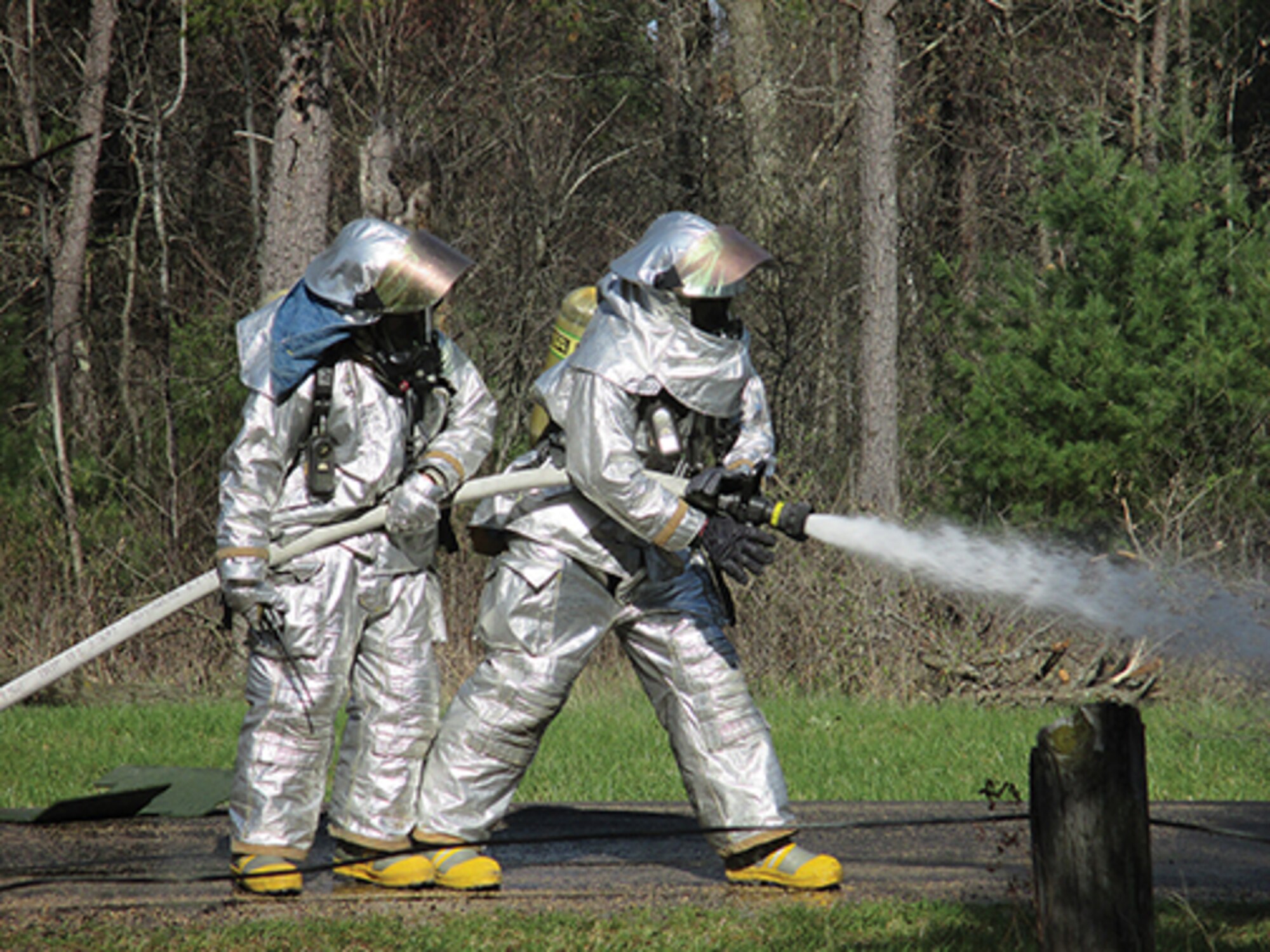 Firefighters work together to perform strenuous duties putting out a roadside fire and proper procedures for handling a roadside bomb during the 908th CES' recent deployment to Fort McCoy, Wis.