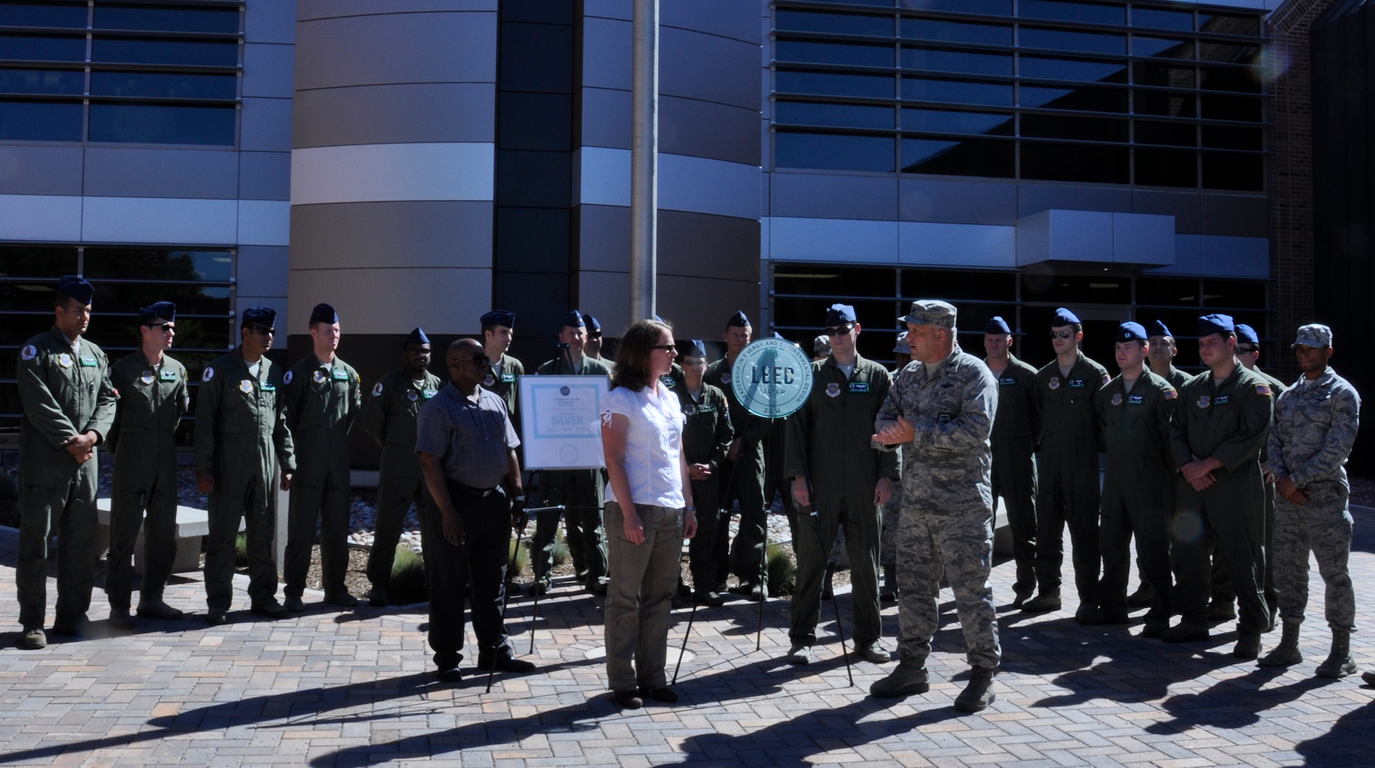 Lt. Col. Jason Terry, right, 52nd Airlift Squadron commander, accepted the certified Leader in Energy and Environmental Design Silver award from Heather Duggan, from the Peterson-based Army Corps of Engineers in front of the award-winning building during a ceremony July 22, 2014 at the 302nd Airlift Wing campus. The building, completed in 2012 is only one of four Silver award-winning buildings on Peterson Air Force Base, Colo. (U.S. Air Force photo/Master Sgt. Daniel Butterfield) 