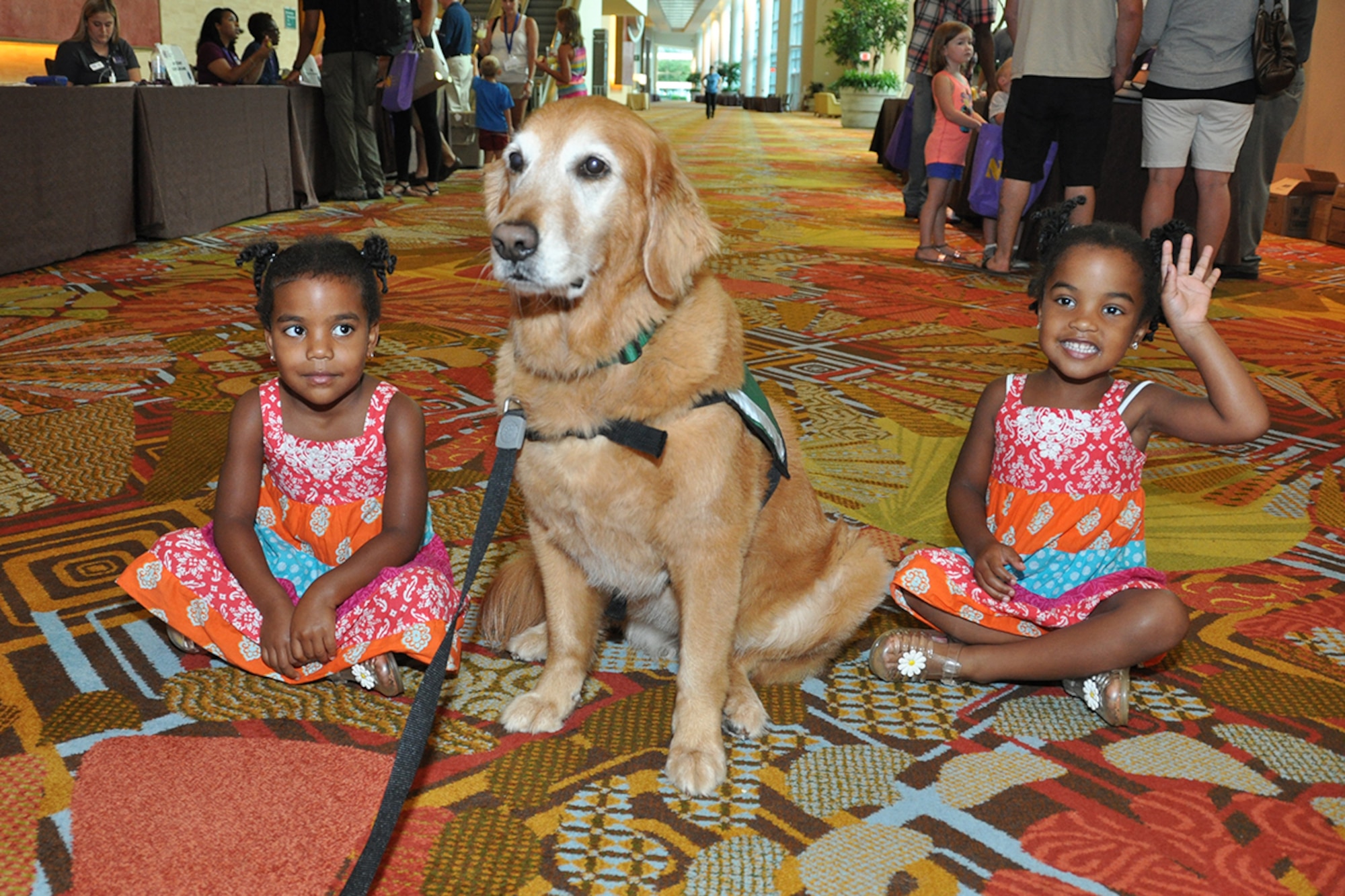 Tess, a Hope Animal-Assisted Crisis Response K-9, interacts with Geneviene and Elizabeth Cherington, daughters of Senior Master Sgt. Anthony Cherington, 482nd Maintenance Squadron flight chief, Homestead Air Reserve Base, Florida, during a Yellow Ribbon event in Orlando, Florida July 25, 2014. The Yellow Ribbon Program promotes the well-being of reservists and their families by connecting them with resources before and after deployments. (U.S. Air Force photo/Master Sgt. James Branch)