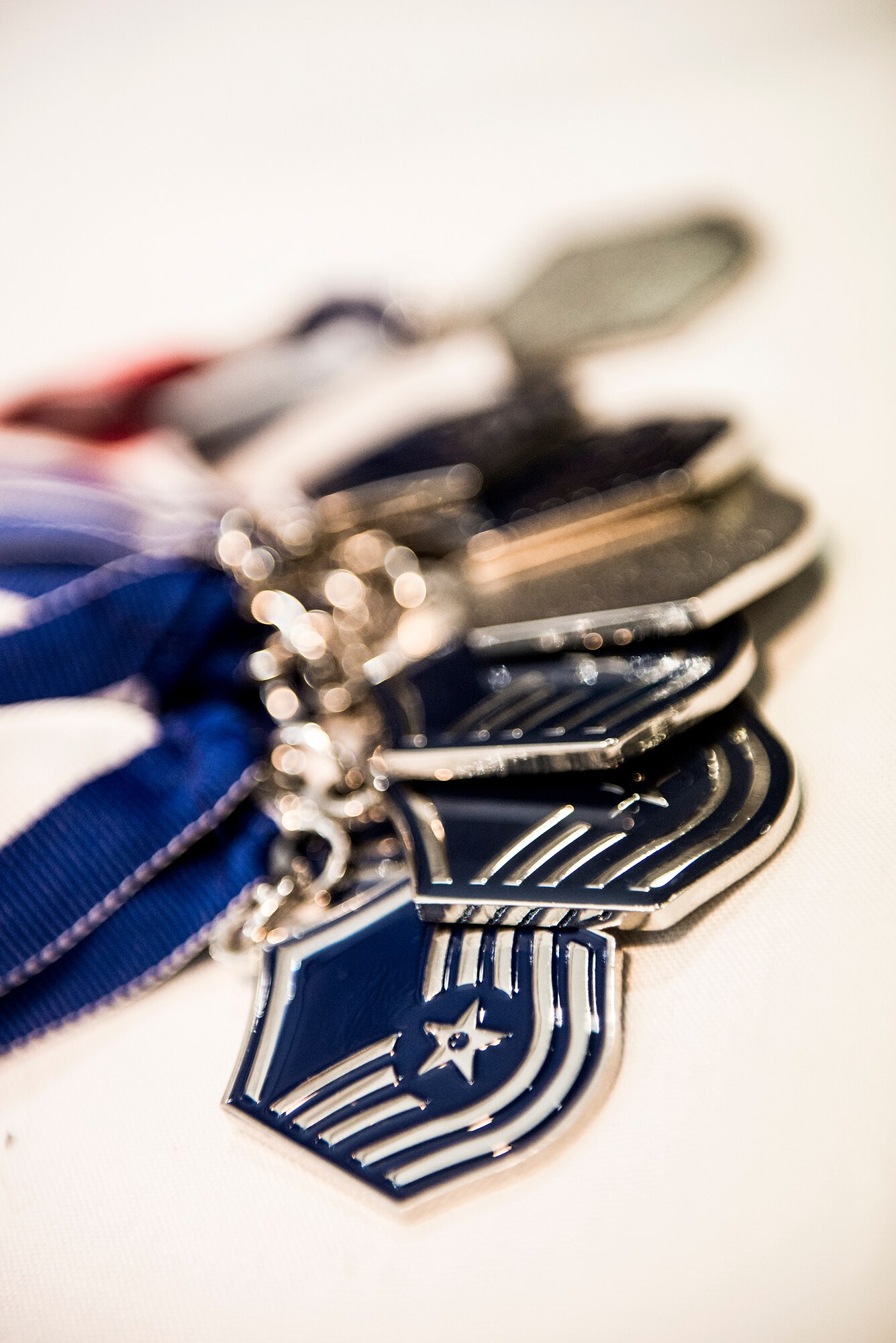 Master sergeant medals rest on a table during a Senior NCO induction ceremony at Moody Air Force Base, Ga., July 25, 2014. Prior to the ceremony, the inductees were given a master sergeant medal to wear. (U.S. Air Force photo by Airman 1st Class Ceaira Tinsley/Released)
