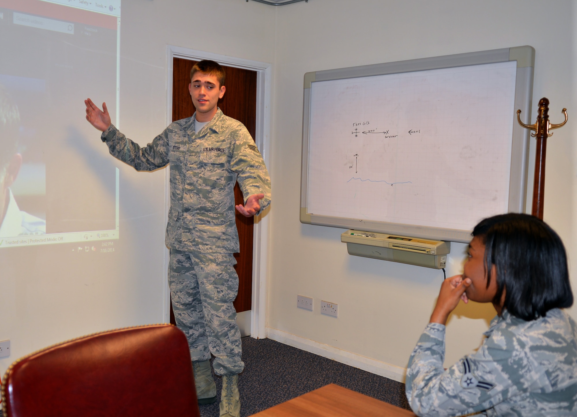 U.S. Air Force Senior Airman Allan Otero, left, 7th Special Operations Support Squadron intelligence operations analyst from Ocala, Fla., briefs U.S. Air Force Airman 1st Class Whitney Gamble, 7th SOSS aviation resource manager from Bronx, N.Y., on current intelligence July 16, 2014, on RAF Mildenhall, England. Otero earned the Square D Spotlight for exhibiting the Air Force Core Value of Excellence in All We Do. (U.S. Air Force photo/Airman 1st Class Kyla Gifford/Released) 