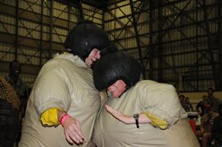 JOINT BASE CHARLESTON, S.C. – Chief Master Sgt. Robert Valenca, 628th Mission Support Group superintendent, battles Master Sgt. Crystal Kasch, 628th Medical Group acting superintendent, during a sumo match at the 2014 Triple Pack Combat Dining Out ceremony July 26, 2014, at Joint Base Charleston, S.C.  The “Combat” Dining Out descends from a military tradition of Dining Out ceremonies, which foster esprit de corps among service members and their leaders. (U.S. Air Force photo/1st Lt. Christopher Love)