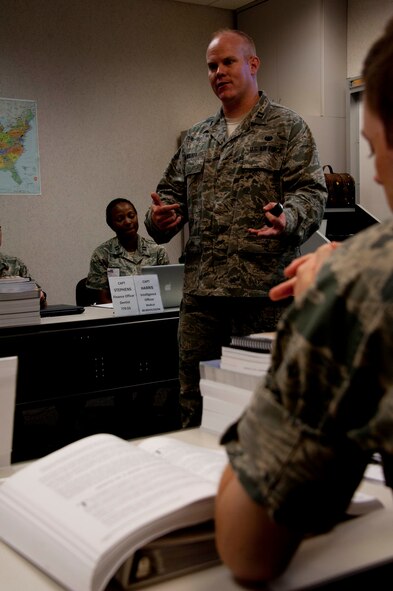 Capt. Brian Walker, 23rd Training Squadron Commissioned Officer Training course instructor, lectures his flight at Officer Training School COT complex, July 17, 2014. Walker is the first judge advocate to teach COT. He is also an Air Force Reserve member, and owns a law practice in Fort Worth Texas. The school often integrates Reserve and Guard members into their staff to strengthen total force initiatives. (U.S. Air Force photo by Staff Sgt. Natasha Stannard)