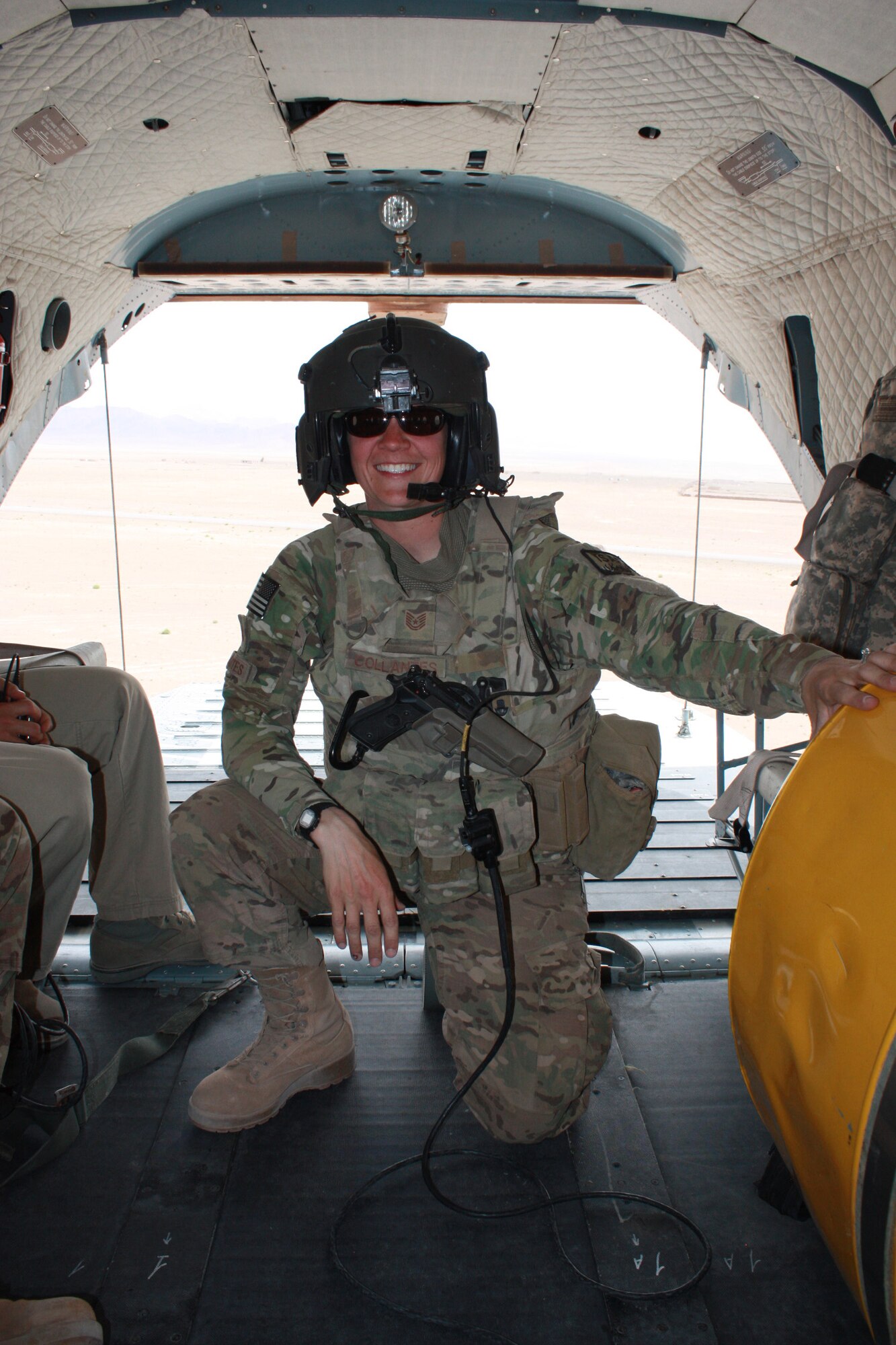 U.S. Air Force Tech. Sgt. Ann Collantes, 802 Air Expeditionary Advisory Squadron air advisor, kneels in a Russian MI-17 aircraft after reenlisting at Shindand Air Base, Afghanistan.  Collantes supports the mission downrange and is a symbol of what an Airman should be while carrying out duties, whether supporting the mission stateside or downrange. (courtesy photo)