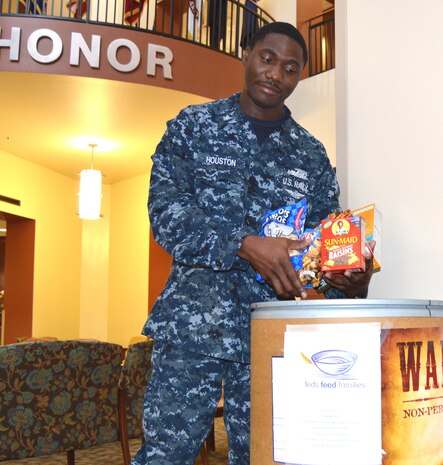 Naval Health Clinic Charleston Petty Officer 2nd Class Anthony Houston, places non-perishable food items recently donated by NHCC staff members in a food collection barrel in the NHCC atrium at Joint Base Charleston, S.C. NHCC is participating in the "Feds Feed Families" campaign to collect food and help combat hunger in our local communities. NHCC has one of several food collection barrels placed at commands around the Weapons Station. Last year the Weapons Station collected more than 3,240 pounds of food. This year’s goal is to increase that amount by 10 percent. While food banks typically see large amounts of food on their shelves over the winter months, donations typically trail off after the holidays are over. Personnel wishing to donate have until the end of August to place non-perishable food items in the designated box in the atrium. Monetary donations may be made through the Religious Offerings Fund at the Weapons Station chapel. Each dollar is the equivalent to five pounds of food. (U.S. Navy Photo/Petty Officer 3rd Class Caralyn/Mulyk)

