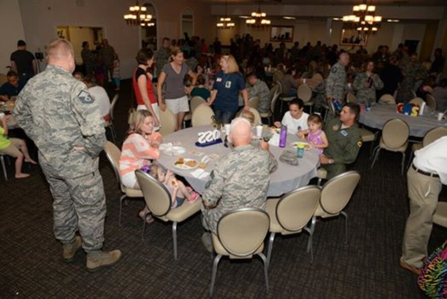 Airmen and family eat and fellowship at the July deployed family dinner at the Carolina Skies Club and Conference Center at Shaw Air Force Base, S.C., July 28, 2014. The dinners are a time for the families of deployed Airmen and Soldiers stationed at Shaw to get together and support each other. (U.S. Air Force photo by Airman 1st Class Jonathan Bass/Released)