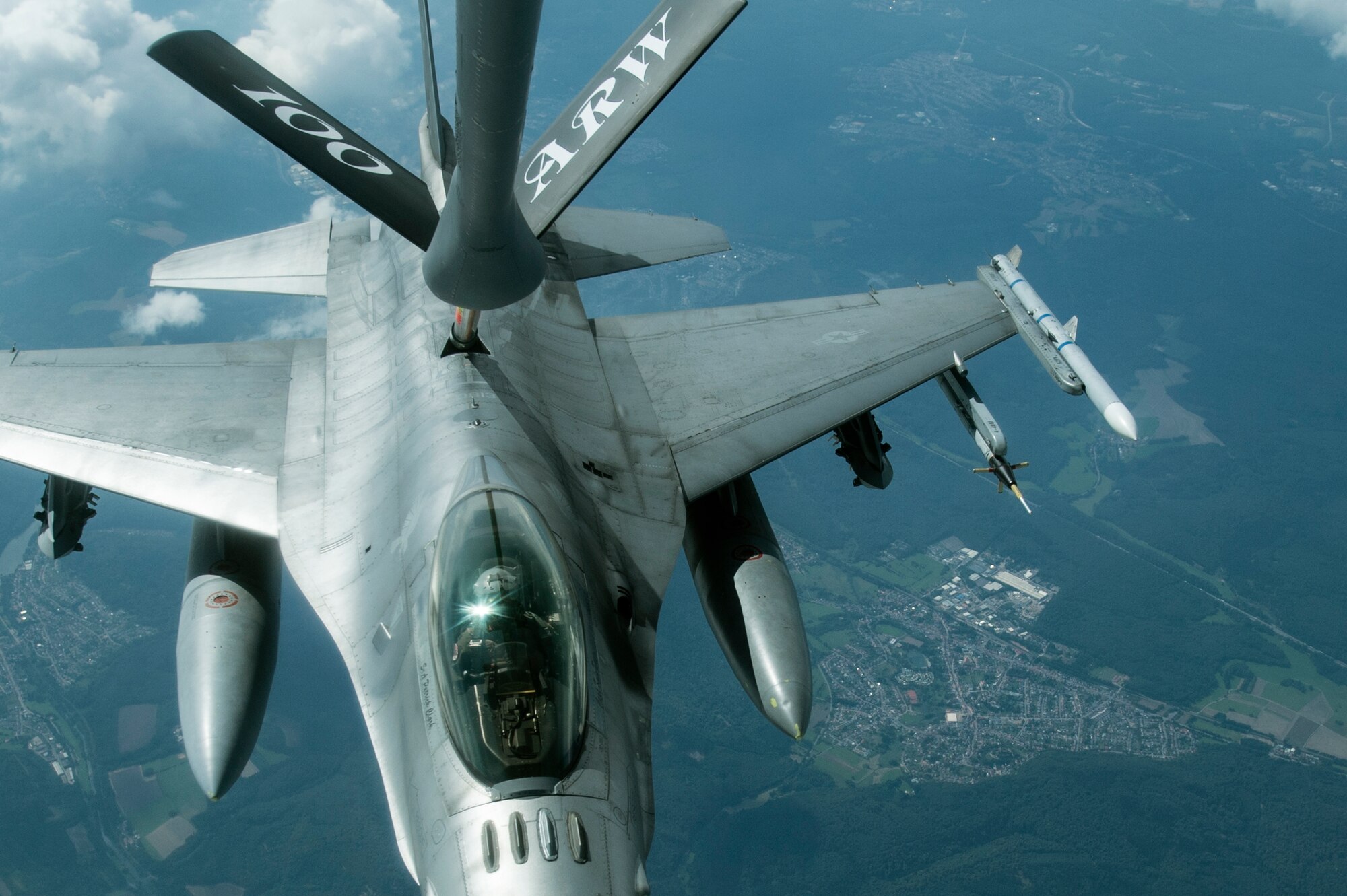 A U.S. Air Force F-16 Fighting Falcon fighter aircraft assigned to Spangdahlem Air Base, Germany, receives fuel from a KC-135 Stratotanker assigned to Royal Air Force Mildenhall, England, during a training mission over Ramstein, Germany, July 24, 2014. Refueling in the air allows pilots to fly twice as long. (U.S. Air Force photo illustration by Senior Airman Rusty Frank/Released)