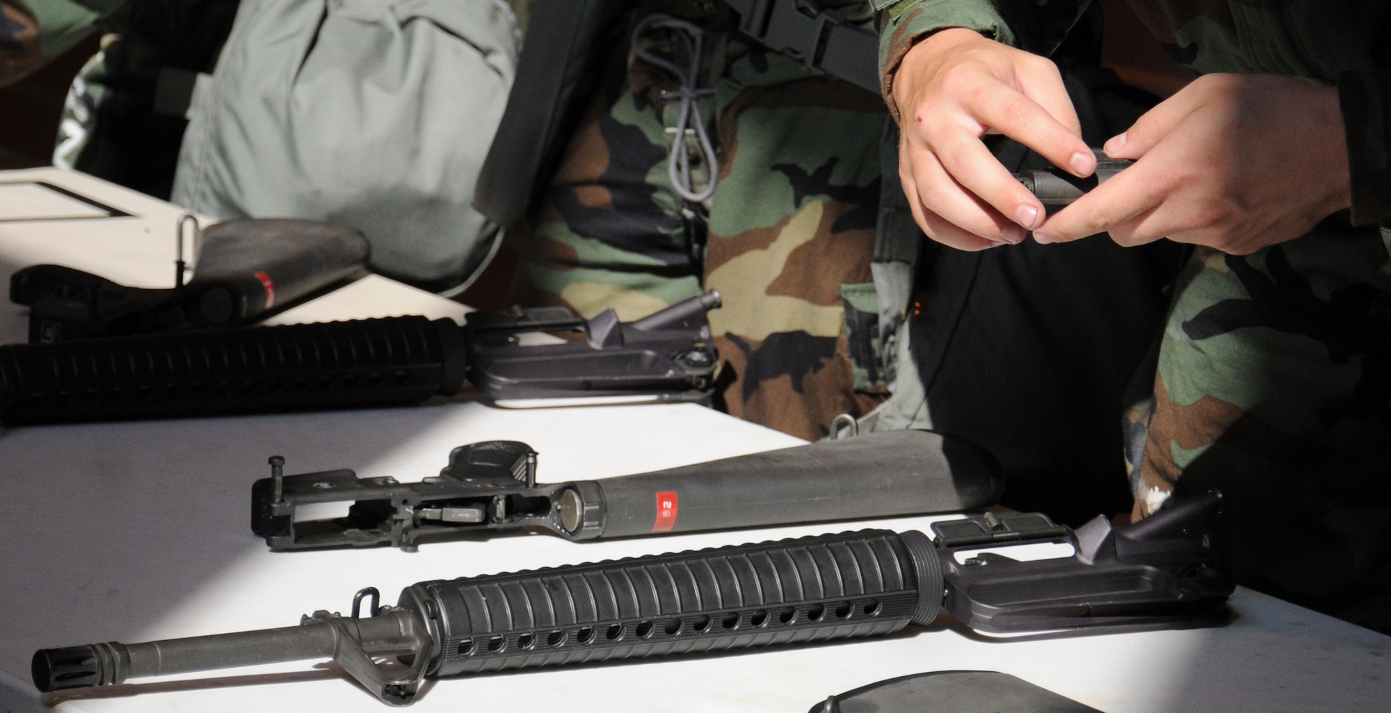A Team Mildenhall member examines the components of a weapon during training July 25, 2014, on RAF Mildenhall, England. Airmen from the 100th Security Forces Squadron taught Team Mildenhall members how to operate a weapon to ensure they are ready to defend the base resources. (U.S. Air Force photo/Gina Randall/Released)