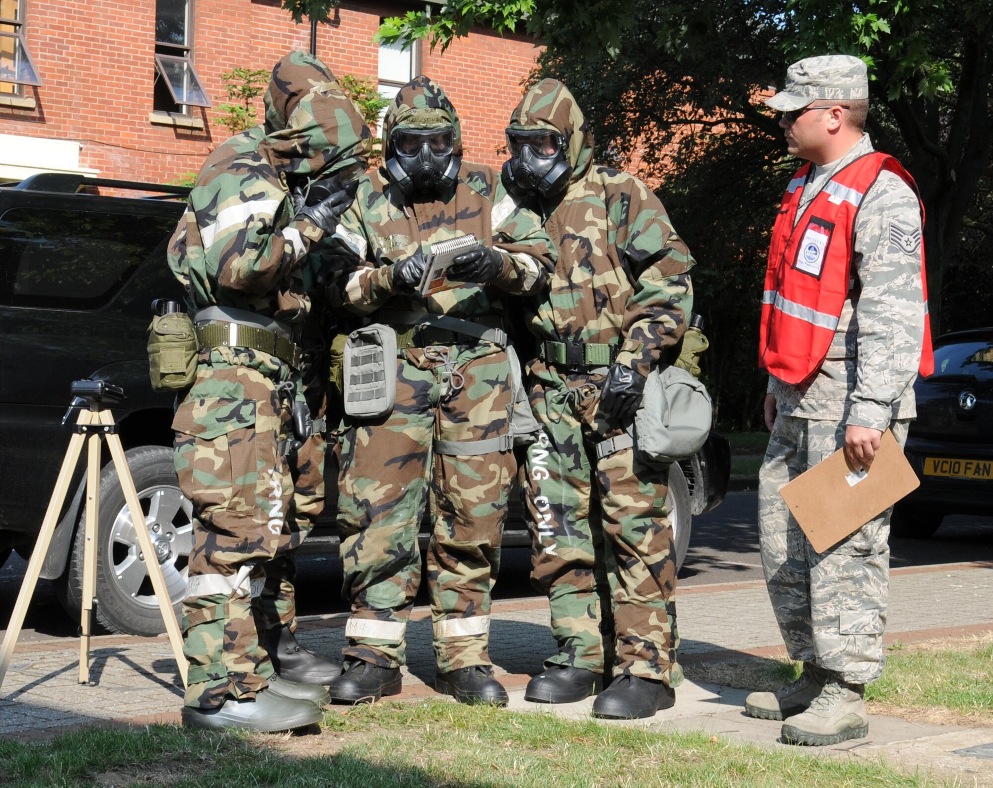 U.S. Air Force Staff Sgt. Geoffrey Wadsworth, right, 100th Civil Engineer Squadron emergency management craftsman from Westborough, Mass., evaluates Airmen from the 100th Air Refueling Wing and the 352nd Special Operations Group during an ability to survive and operate and chemical, biological, radiological and nuclear exercise July 25, 2014, on RAF Mildenhall, England. Wadsworth evaluated the post-attack reconnaissance team. Airmen from the 100th Security Forces Squadron and the 100th CES taught attendees how to operate a weapon to ensure they are ready to defend the base and its population. (U.S. Air Force photo/Gina Randall/Released)