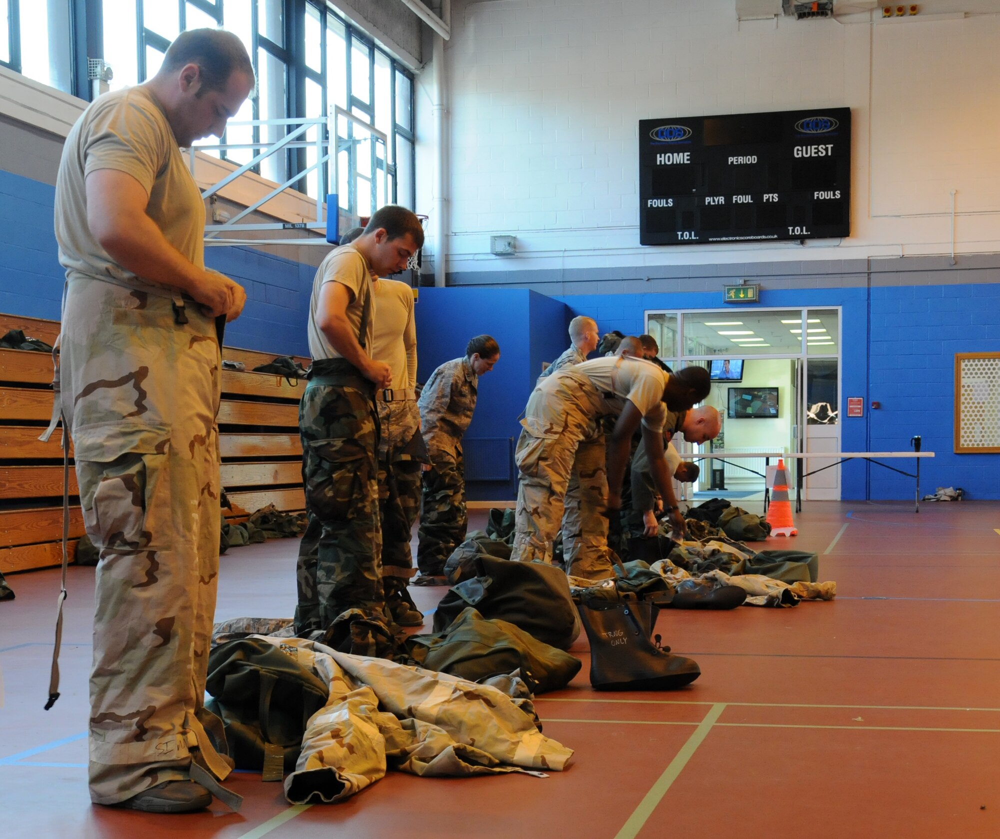 Team Mildenhall members dress in full personal protective equipment during training July 25, 2014, in the Northside Fitness Center on RAF Mildenhall, England. Airmen practiced self-aid buddy care, weapon operation and ability to survive and operate and chemical, biological, radiological and nuclear tasks while dressed in full mission-oriented protective posture gear to ensure they are prepared to deploy. (U.S. Air Force photo/Gina Randall/Released)