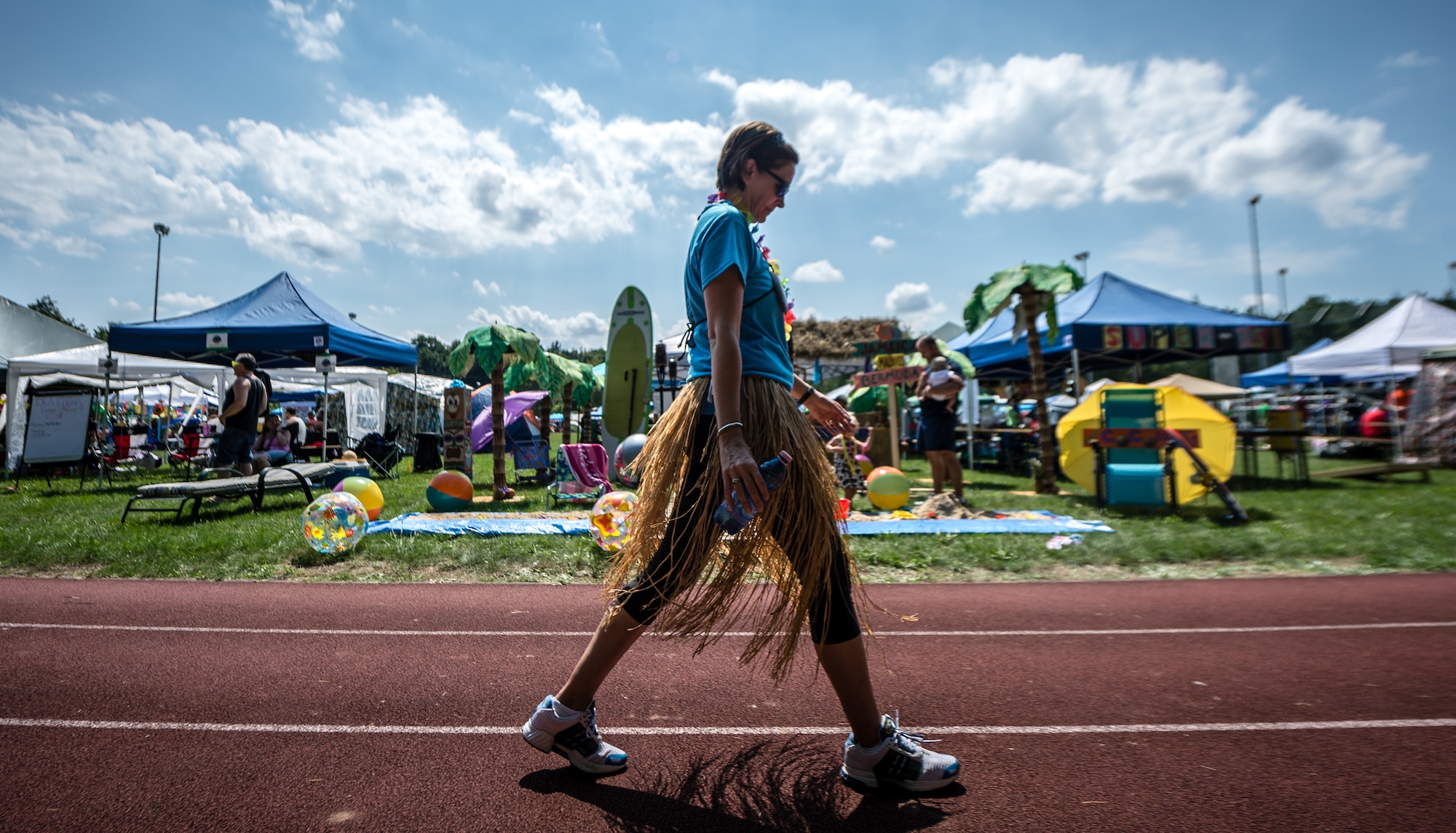 Linda Mandell, U.S. Air Forces in Europe Protocol specialist, walks past a tropical themed camp during the Viking Challenge July 25, 2014 at the Pulaski Park track, Germany. The Viking Challenge is a fundraising event that supports a local chapter of the Fisher House Foundation. (U.S. Air Force photo/Airman 1st Class Jordan Castelan)