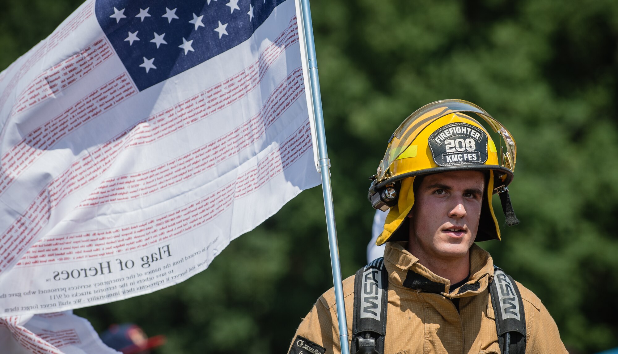 Airman 1st Class William Campbell, 86th Civil Engineer firefighter, carries a decorated American flag during the Viking Challenge, July 25, 2014 at the Pulaski Park track, Germany. The Viking Challenge is a fundraising event that supports a local chapter of the Fisher House Foundation. (U.S. Air Force photo/Airman 1st Class Jordan Castelan)