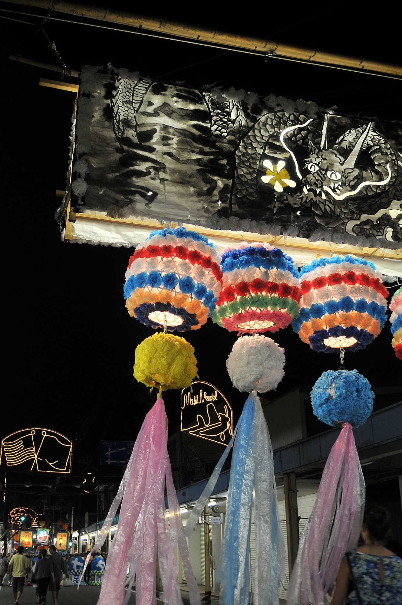 Misawa City residents walk past Tanabata decorations near Misawa Air Base, Japan, July 26, 2014. Thousands of Misawa AB and Misawa City families attended the annual event, which is based off of a 2,000 year-old Chinese legend of two lovers who could only meet once a year. (U.S. Air Force photo/Staff Sgt. Tong Duong)