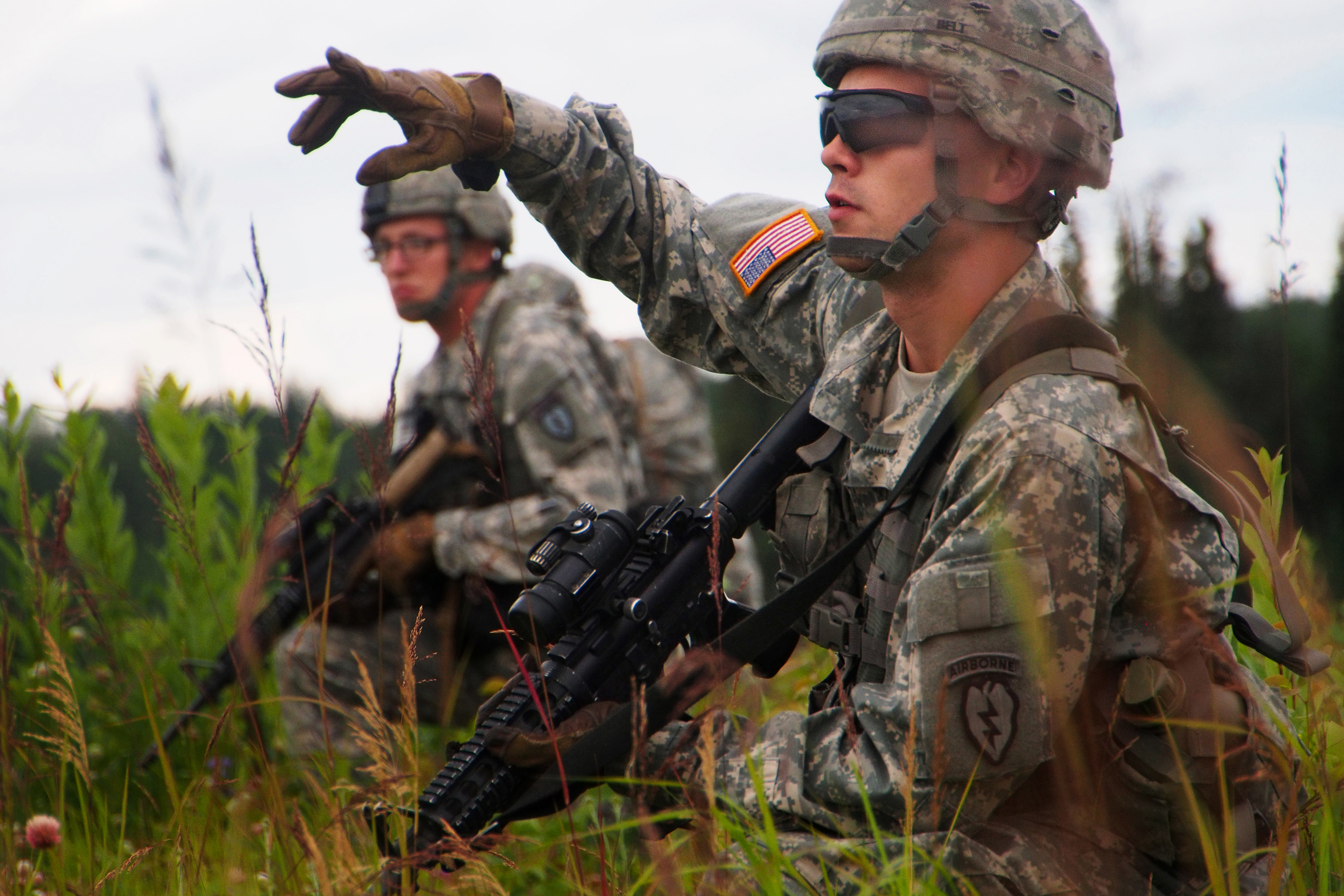 Army Pfc. Randy Belt, foreground, directs fellow soldiers to a rally