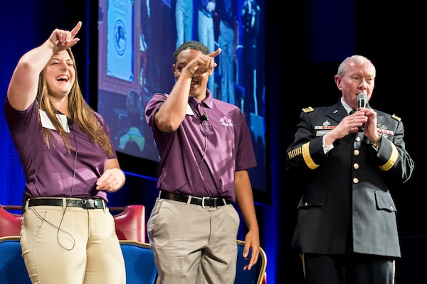 Chairman of the Joint Chiefs of Staff Gen. Martin E. Dempsey sing a song at the Military Education Coalition 2014 National Training Seminar along with six children selected for their work with the organization at the Washington Marriott Wardman Park in Washington D.C., July 29, 2014. The coalition works with leading national experts in child development, education and health to support military children.