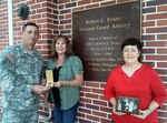 Florida Army National Guard Sgt. 1st Class Carlton Cooley accepts the Silver Star medal of Staff Sgt. Robert Evans from Evans' neices Deborah Lynne Evans Watts (center) and Beverly Evans Srock, at the National Guard Armory in Sanford, Fla., Jan. 10, 2012. Evans, a medic serving with the 124th Infantry Regiment's Medical Detachment, was awarded a posthumous Silver Star after he died in action in the Philippines in 1945. The armory, which was later named after Evans, is now home to B Company, 2nd Battalion, 124th Infantry Regiment. In this photo, Srock is holding a black-and-white photo of Evans' brother Earl receiving the Silver Star for his late brother