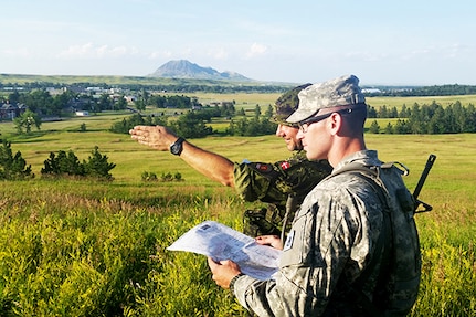 Danish Home Guard 1st Lt. Jannick B. Reumann instructs a U.S. Army National Guard officer candidate on land navigation, July 16, 2014, at Fort Meade, S.D. Reumann, along with 14 other Danish Home Guard instructors, completed U.S. Army Basic Instructor Course training, July 1-4, in Denmark through a DoD Officers Foreign Exchange Program, in cooperation with the South Dakota Army National Guard. Danish Home Guard instructors were then selected to come to South Dakota to serve as Officer Candidate School instructors, July 13-26.