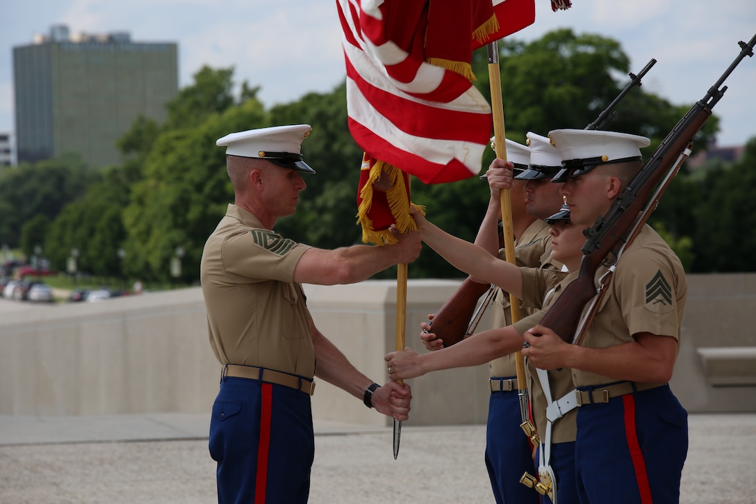 Sgt. Maj. John Hawes, sergeant major of the 9th Marine Corps District, retrieves the organizational colors from the color guard to present to Col. James Minick who relinquished command to Col. Jason Morris July 18, at the Liberty Memorial. Morris will assume command following the district's relocation to Great Lakes Naval Training Center, Great Lakes, Ill.