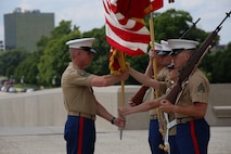 Sgt. Maj. John Hawes, sergeant major of the 9th Marine Corps District, retrieves the organizational colors from the color guard to present to Col. James Minick who relinquished command to Col. Jason Morris July 18, at the Liberty Memorial. Morris will assume command following the district's relocation to Great Lakes Naval Training Center, Great Lakes, Ill.