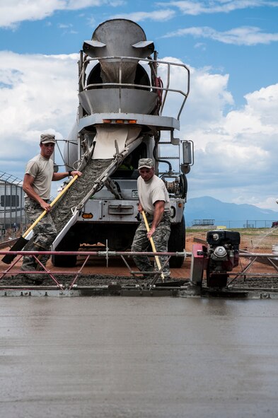 (From left) Airman 1st Class Scott Norfleet, 50th Civil Engineer Squadron, and Master Sgt. David Sweitzer, 911th Civil Engineer Squadron, distribute cement July 25, 2014, at Schriever Air Force Base, Colo. Airmen with 50 and 911 CES worked together for two weeks on various tasks such as pump replacement for fire suppression, water pump service, road sign replacement, office renovations, heating, ventilation and air conditioning and electrical work orders and various other trouble tickets. (U.S. Air Force photo/Staff Sgt. Julius Delos Reyes)