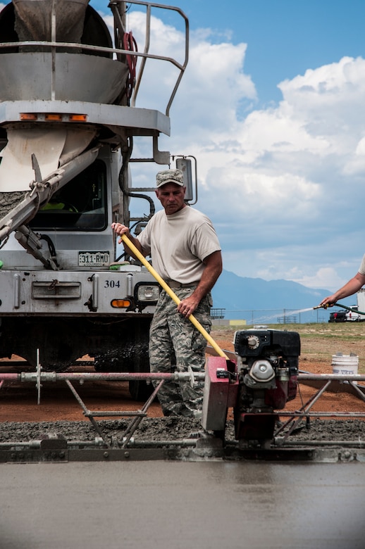 Master Sgt. David Sweitzer, 911th Civil Engineer Squadron, distributes cement July 25, 2014, at Schriever Air Force Base, Colo. Sweitzer was at Schriever as part of his unit’s annual tour requirement. The 911 CES is stationed at Pittsburgh Air Reserve Station, Pennsylvania. (U.S. Air Force photo/Staff Sgt. Julius Delos Reyes)