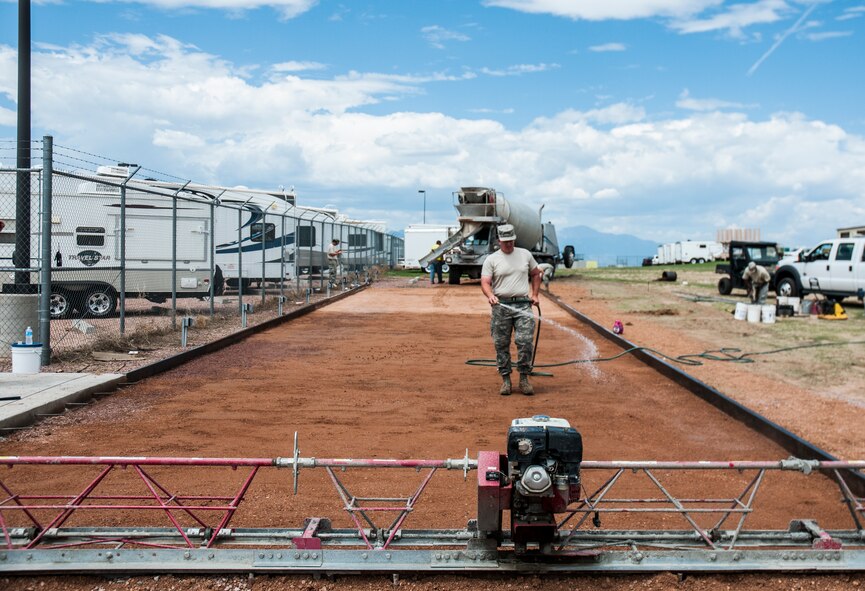 Master Sgt. Timothy Harper, 911th Civil Engineer Squadron, waters the ground for a cement pad July 25, 2014, at Schriever Air Force Base, Colo. Harper and 31 other Airmen with 911 CES conducted various civil engineer projects, such as heating, ventilation and air conditioning and electric work orders, as part of their annual Reserve tour. (U.S. Air Force photo/Staff Sgt. Julius Delos Reyes)