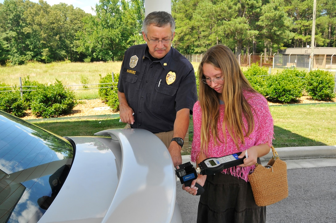 Katherine Hawkins, daughter of Dan Hawkins, operations officer for the Arnold Police Department, experiences firsthand the responsibilities of her dad’s job. Here he shows Katherine how to use a Fido electronic explosive detector to check a vehicle for trace amounts of explosives.