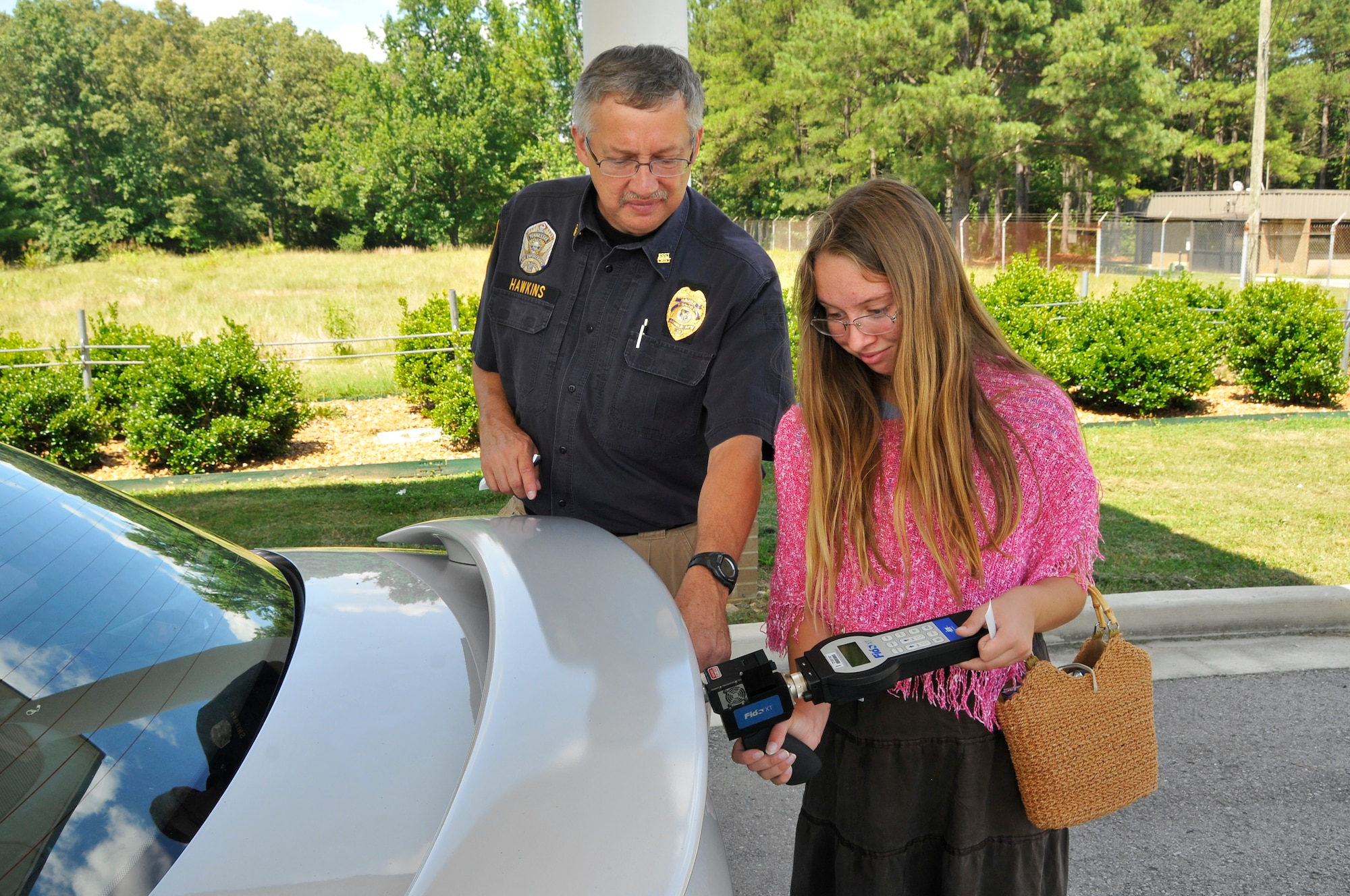 Katherine Hawkins, daughter of Dan Hawkins, operations officer for the Arnold Police Department, experiences firsthand the responsibilities of her dad’s job. Here he shows Katherine how to use a Fido electronic explosive detector to check a vehicle for trace amounts of explosives.
