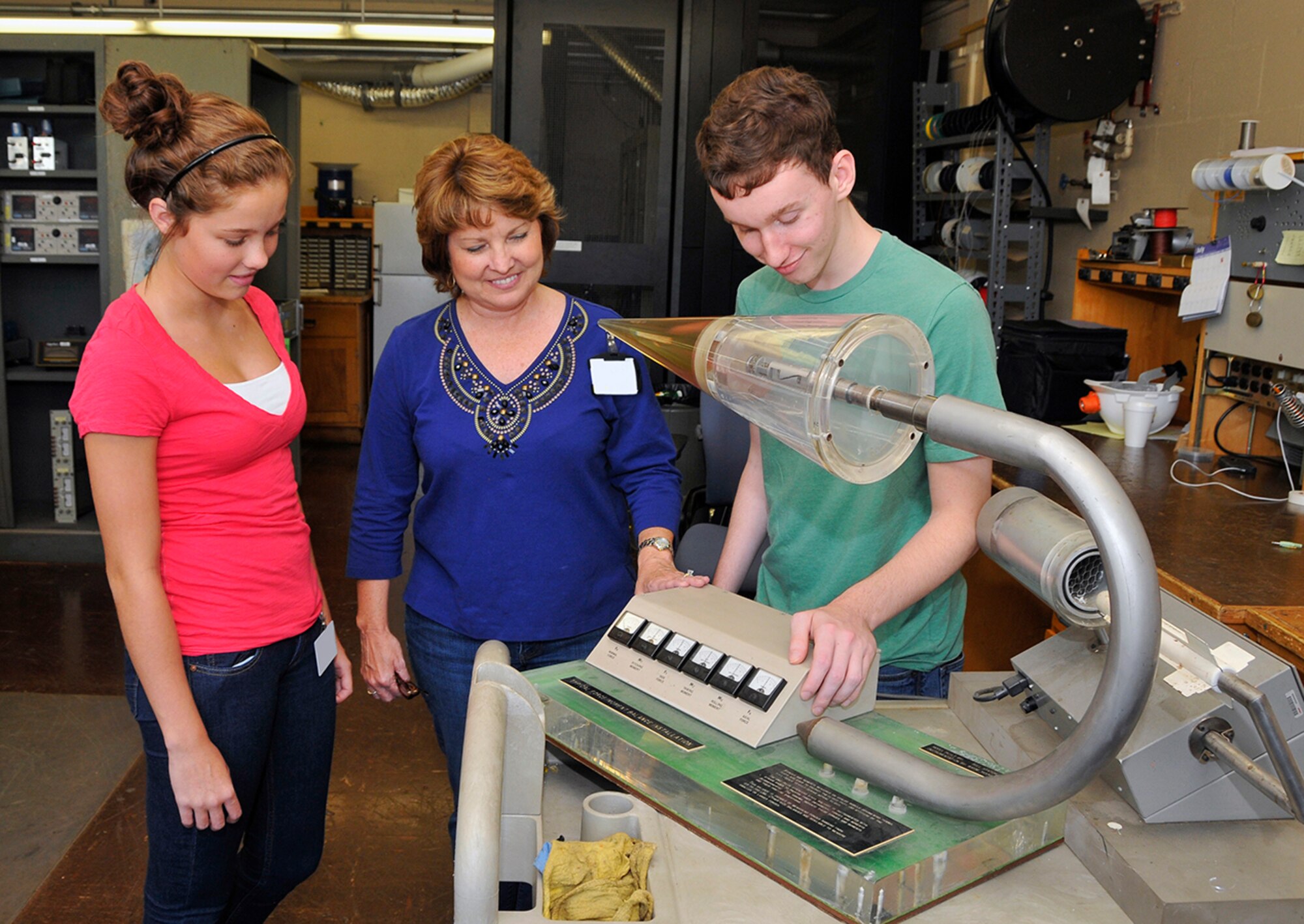 Alexis Loman and Samuel Oliver spent the day shadowing their mom, Susan Loman, group lead for the Data Processing and Analysis Development and Support Group, at the von Kármán Facility. Here Susan shows her son and daughter a balance simulator in the VKF lab.