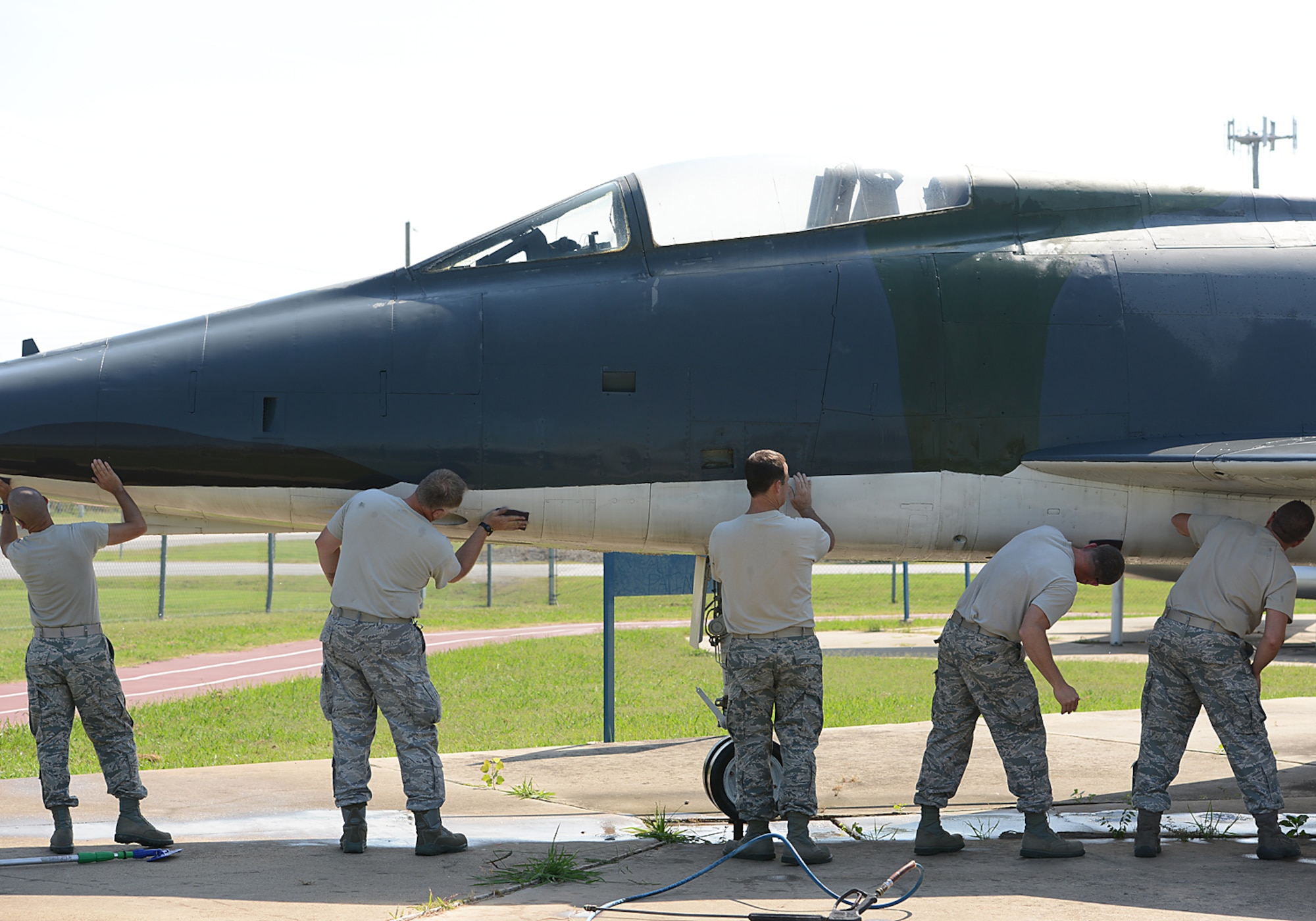 Chief Master Sergeants of the 138th Fighter Wing, wash an F-100 static display aircraft at the Tulsa Air National Guard base, Tulsa Okla., 29 July 2014.  Members of the 138th FW Chiefs Council gathered to wash the static aircraft in an effort to keep them looking nice for public display.  (U.S. National Guard photo by Senior Master Sgt.  Preston L. Chasteen/Released)