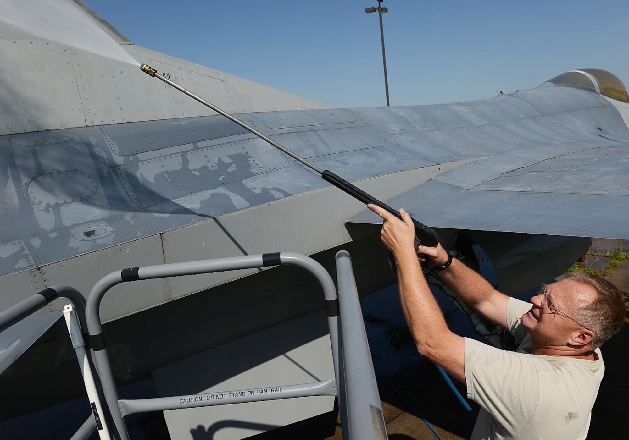 Chief Master Sergeant Jim Embrey, 138th Maintenance Squadron Chief,  power washes the fuselage of an F-16 static display aircraft at the Tulsa Air National Guard base, Tulsa Okla., 29 July 2014.  Members of the 138th FW Chiefs Council gathered to wash the static aircraft in an effort to keep them looking nice for public display.  (U.S. National Guard photo by Senior Master Sgt.  Preston L. Chasteen/Released)