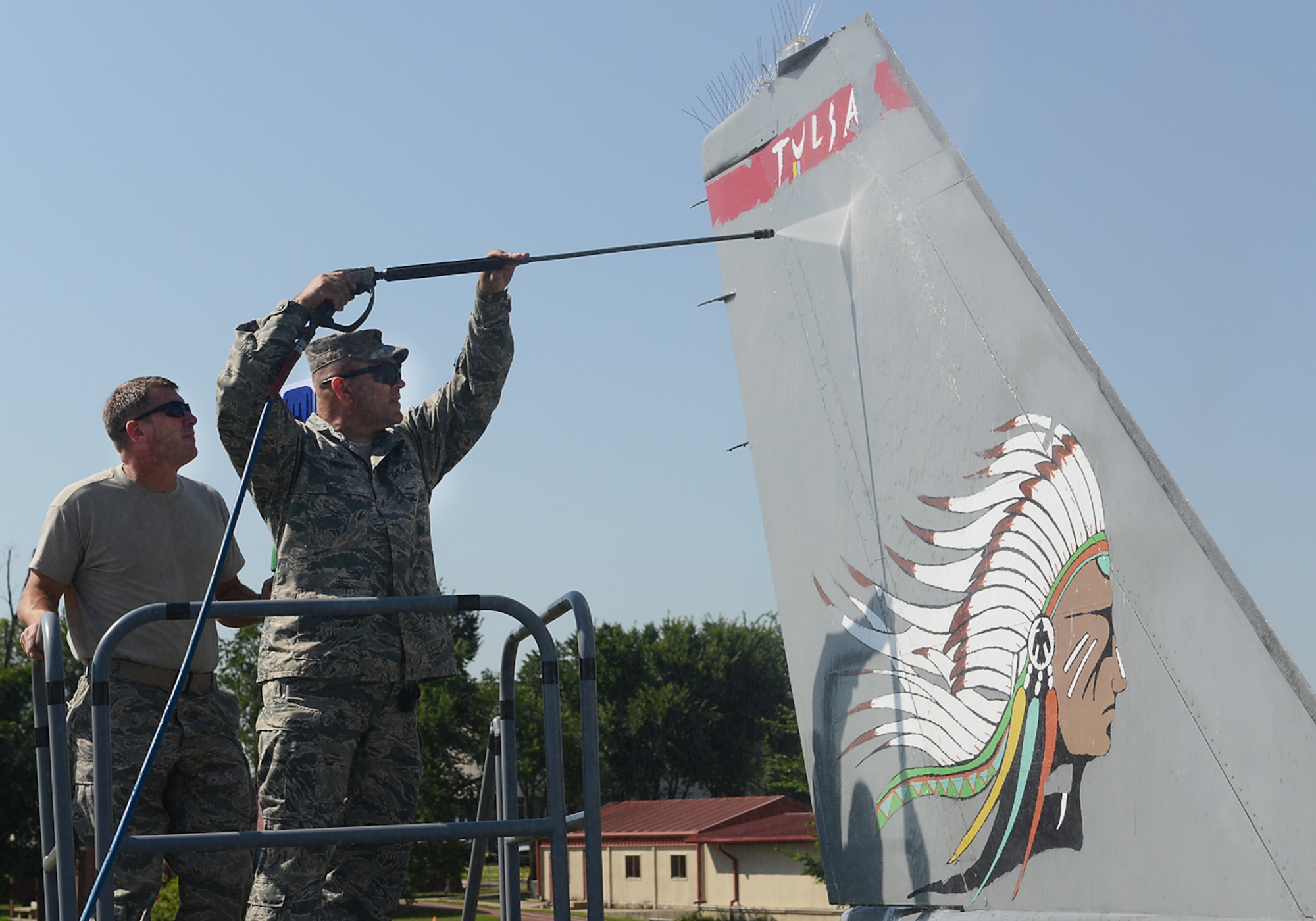 Lieutenant Colonel Travis Brown, 138th Maintenance Squadron Commander and Chief Master Sergeant Tracey Weaver, 138th Aircraft Maintenance Chief, power wash the tail of an F-16 static display aircraft at the Tulsa Air National Guard base, Tulsa Okla., 29 July 2014.  Members of the 138th FW Chiefs Council gathered to wash the static aircraft in an effort to keep them looking nice for public display.  (U.S. National Guard photo by Senior Master Sgt.  Preston L. Chasteen/Released)