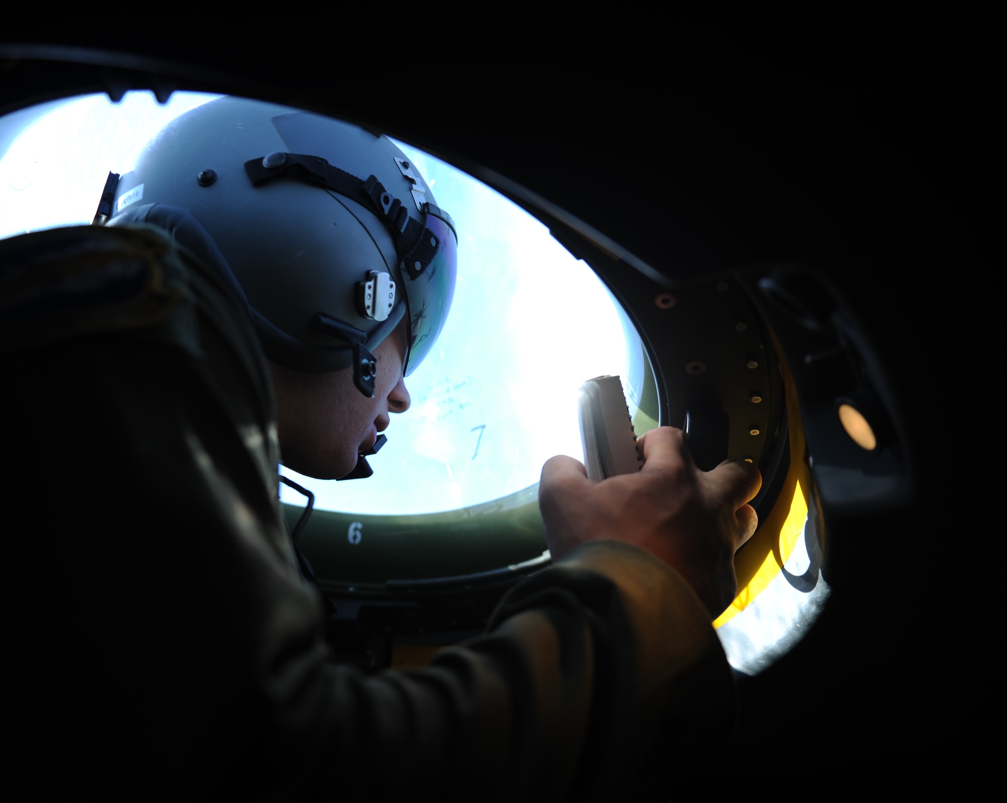U.S. Air Force Airman 1st Class Jacob Betts, 40th Airlift Squadron loadmaster, watches an F-16 Fighting Falcon from a bubbled window on board a C-130J Super Hercules July 23, 2014, en route to Naval Air Station Joint Reserve Base Fort Worth, Texas. During a training exercise, C-130J pilots reacted to the movements of the F-16 and maneuvered to ensure the safety of their aircraft. (U.S. Air Force photo by Airman 1st Class Kedesha Pennant/Released)