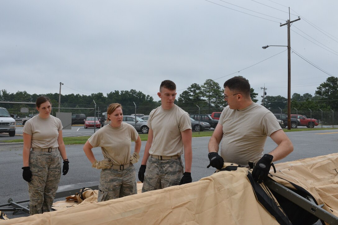 (Left to right): Airman First Class Katherine Welsh, Senior Airman Matti Schake, Airman First Class James Witter, and Tech. Sgt. Rusty Zortman, members of the 155th Sustainment Services Flight, don a temper tent for a mobile kitchen to serve several meals to the 155th Small Air Terminal Airmen, as part of their annual proficiency training at the Transportation Proficiency Center, Dobbins Air Reserve Base, Georgia, July 11-14, 2014. Zortman, the Force Support Squadron's Programs non-commissioned officer in charge, teaches his Airmen step-by-step how to properly lace the roof of the tent together.