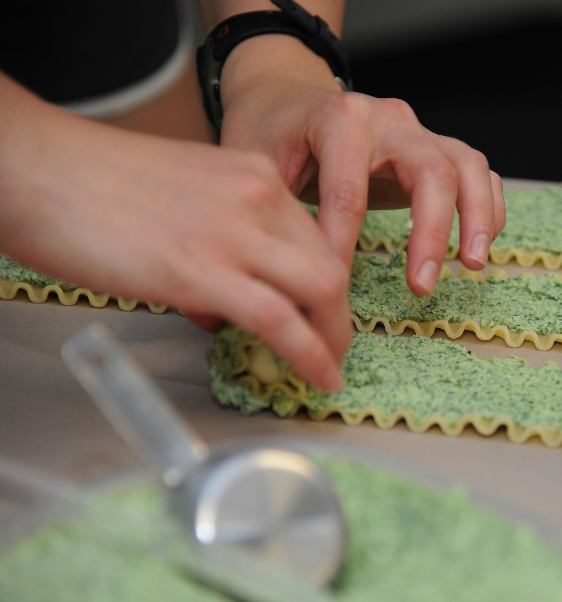 VANCE AIR FORCE BASE, Okla. -- 2nd Lt. Jessica Franklin, a 71st Flying Training Wing Protocol assistant, rolls pasta pinwheels for the monthly Singles' International Gourmet Meal Opportunity event at the Community Chapel Activities Center July 28. SIGMO is a free, home-cooked meal for single Airmen, single parents, unaccompanied Airmen of all ranks and the families of deployed members.  (U.S. Air Force photo/Staff Sgt. Nancy Falcon)