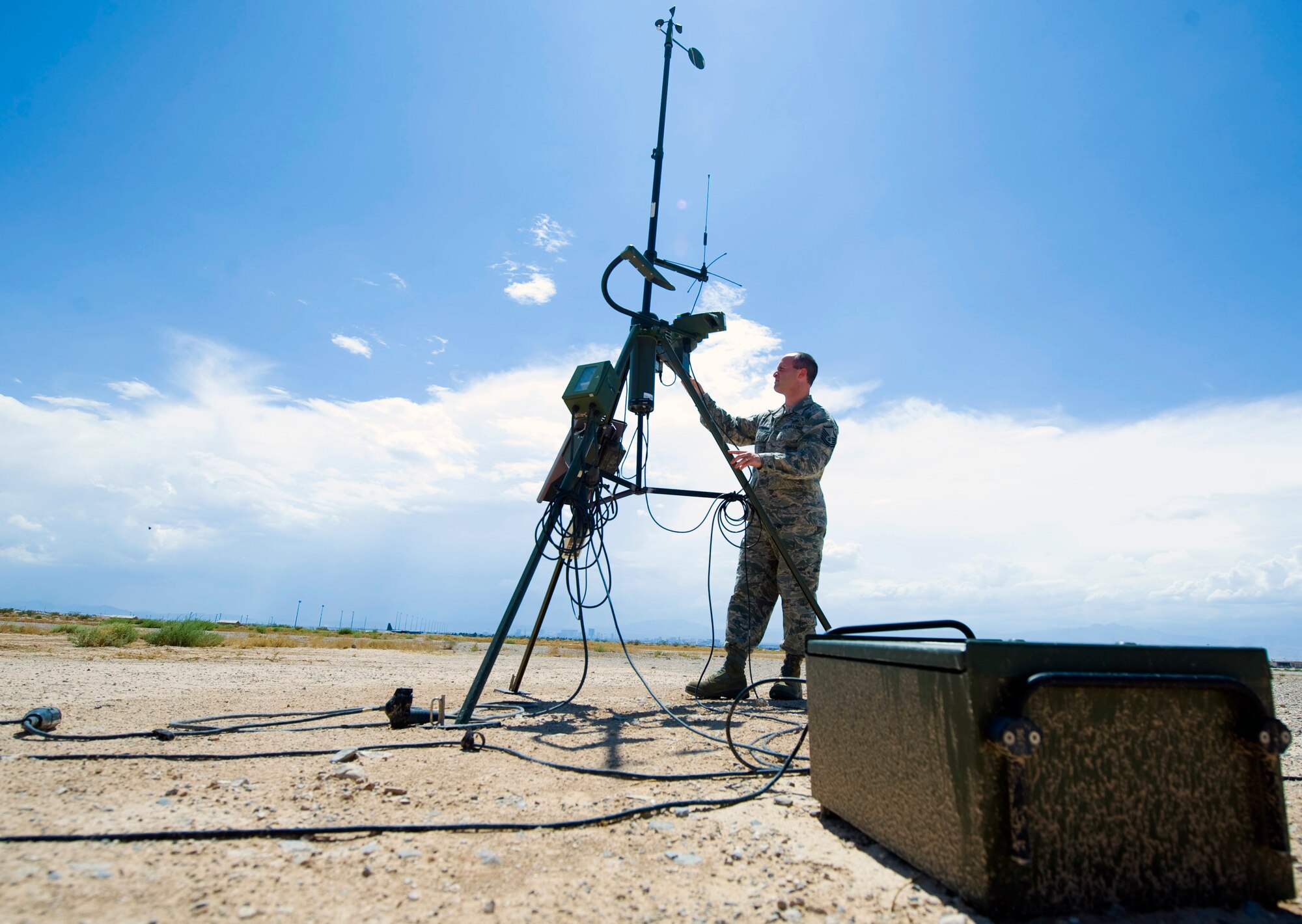 Master Sgt. Adam D'Anthony, 57th Operations Support Squadron airfield weather support NCO in charge, checks a Tactical Meteorological Set July 28, 2014, at Nellis Air Force Base, Nev. The TMQ-53 measures wind speed, direction, temperature, dew point, atmospheric pressure, visibility and is utilized in deployed environments. (U.S. Air Force photo by Airman 1st Class Rachel Loftis)