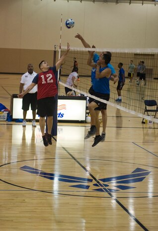 A member of the 57th Maintenance Squadron’s intramural volleyball team [red] jumps up to block a ball hit by a member of the 99th Security Forces Squadron [blue] during an intramural volleyball game at the Warrior Fitness Center, July 28,2014, at Nellis Air Force Base, Nev. Intramural sports are a good way to increase camaraderie between squadrons. (U.S. Air Force photo by Airman 1st Class Mikaley P. Towle)   
