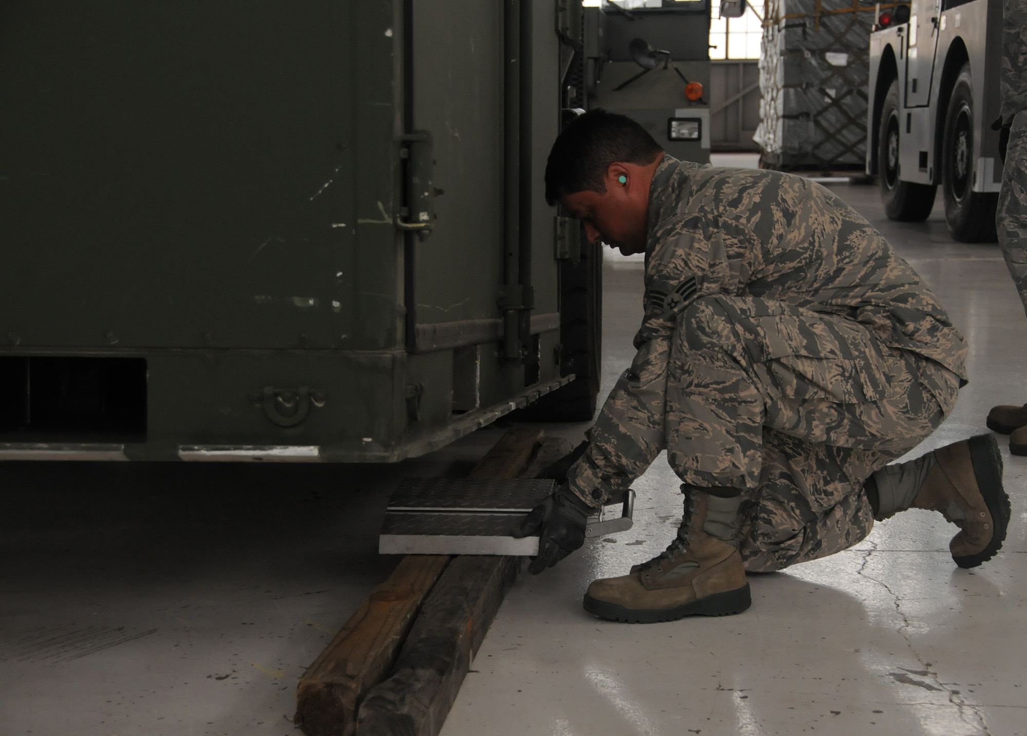 WRIGHT-PATTERSON AIR FORCE BASE, Ohio – Senior Airman Abraham Cancel, 87th Aerial Port Squadron, places a scale under a cargo shipping container during cargo building training during the July 19, 2014 unit training assembly. (U.S. Air Force photo/Tech. Sgt. Anthony G. Springer)