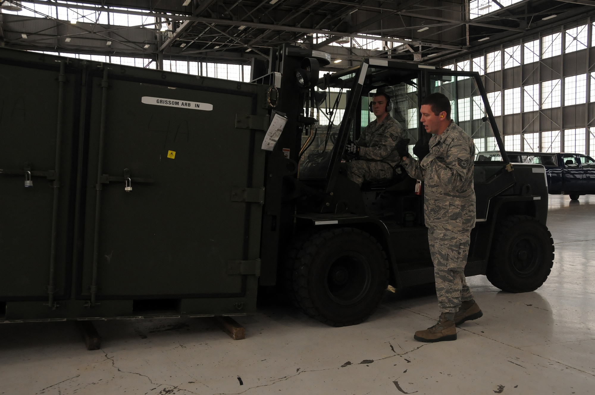 WRIGHT-PATTERSON AIR FORCE BASE, Ohio – Forklift operator, Staff Sgt. Thomas Kocin, receives commands from Tech. Sgt. Matthew Foster in moving a shipping container during pallet build training July 19, 2014. Both are assigned to the 87th Aerial Port Squadron.  (U.S. Air Force photo/Tech. Sgt. Anthony G. Springer)