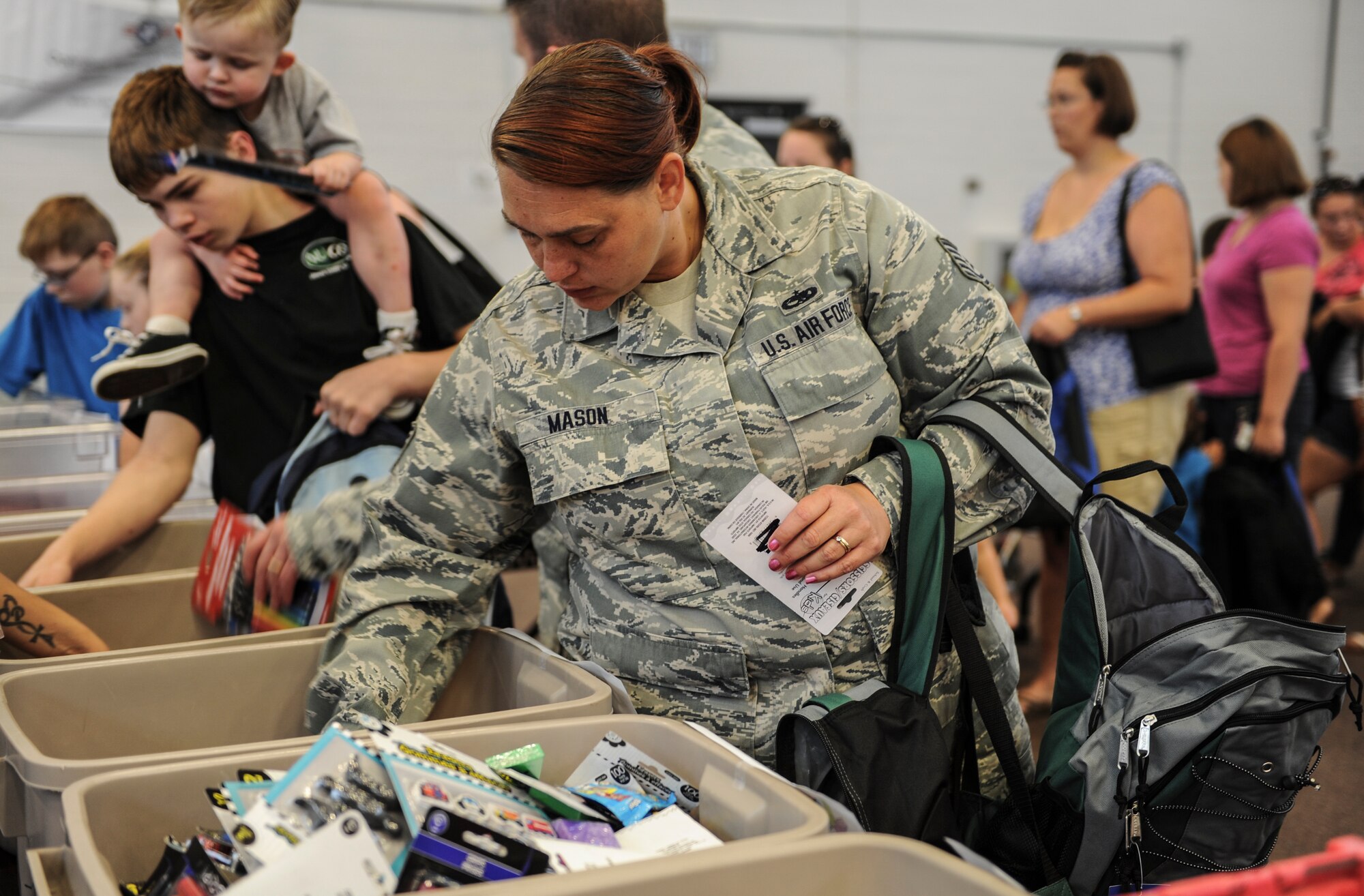 U.S. Air Force Tech. Sgt. Michelle Mason, 23d Aircraft Maintenance Squadron avionics technician, searches through bins during a school supply drive at Moody Air Force Base, Ga., July 30, 2014. Customers of local businesses donated the items, which were collected and gathered through the Operation Homefront program. (U.S. Air Force photo by Airman 1st Class Alexis Millican/Released) 