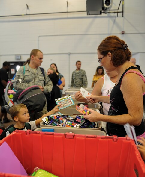 Children and parents pick out school supplies during a school supply drive at Moody Air Force Base, Ga., July 30, 2014. Team Moody families received writing utensils, markers, backpacks and much more to help prepare school-aged children for the start of the school year. (U.S. Air Force photo by Airman 1st Class Alexis Millican/Released)