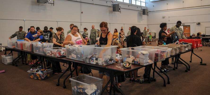 Members of Team Moody line up to receive school supplies for their school-aged children at Moody Air Force Base, Ga., July 30, 2014. Military members, and spouses, ranked from E-1 to E-6 with school age children received the donated school supplies through the Operation Homefront program. (U.S. Air Force photo by Airman 1st Class Alexis Millican/Released)