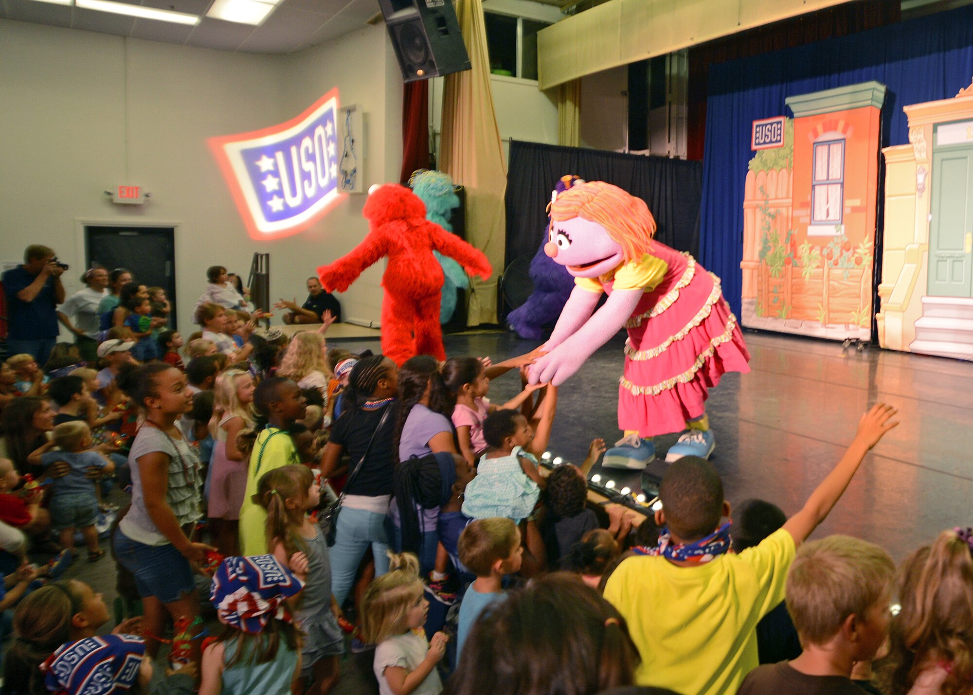 Of the Sesame Street characters in attendance, Katie, a six-year-old girl who learns that her dad, who is in the military, has been transferred to another base, greets military chilren during the "Sesame Street USO Experience for Military Families" July 28 at the Oasis Community Center. (U.S. Air Force photo by Jet Fabara)