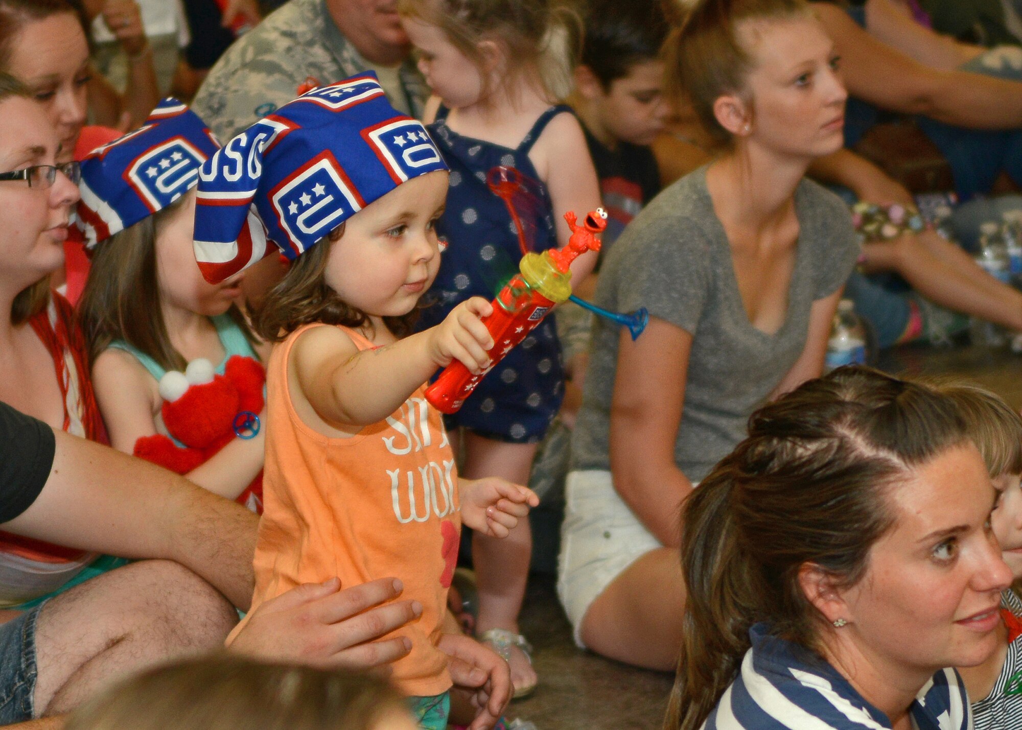 Arabella Ramirez waves her spinning Elmo toy during the "Sesame Street USO Experience for Military Families" show July 28 at the Oasis Community Center. (U.S. Air Force photo by Jet Fabara)