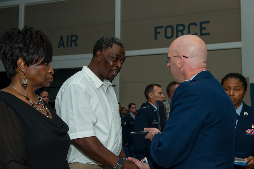 U.S. Air Force Lt. Col. Jason Musser, 23d Aerospace Medicine Squadron commander, presents the Meritorious Service Medal to Brian Dease, during a memorial ceremony for Master Sgt. LaTonya Dease at Moody Air Force Base, Ga., July 29, 2014. Brian is the husband of Master Sgt. Dease. (U.S. Air Force photo by Airman 1st Class Ceaira Tinsley/Released)