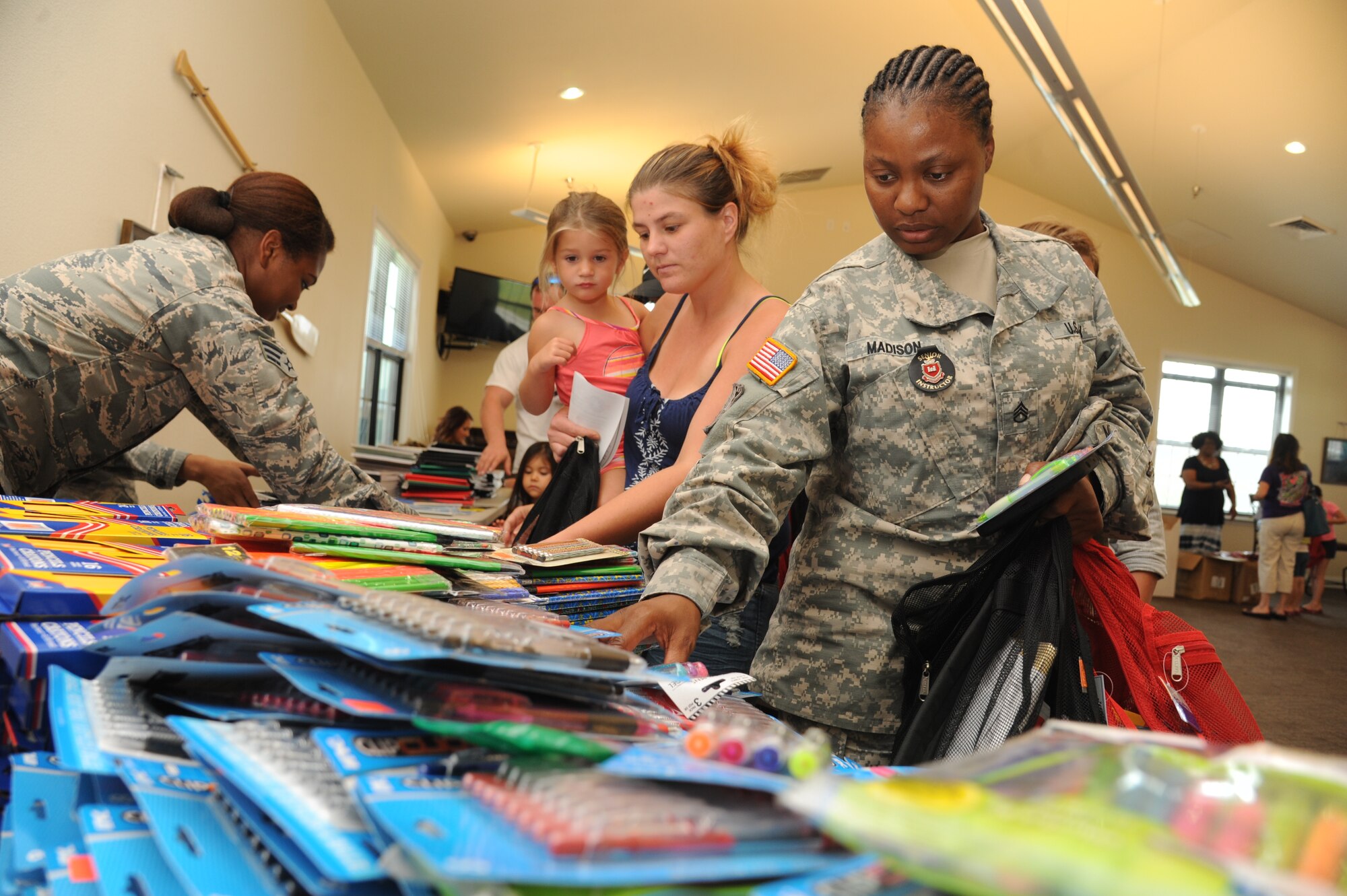 The wife and daughter of Navy Petty Officer 2nd Class Kenneth Huffman and Army Staff Sgt. Corletta Madison, Naval Construction Battalion Center, Gulfport, Miss., follow school supply lists while sorting through the items during a backpack and school supplies give-away event July 29, 2014, at the Bay Ridge Community Center, Keesler Air Force Base, Miss.  The 81st Force Support Squadron and Operation Home Front partnered together to host the event for military families. (U.S. Air Force photo by Kemberly Groue)